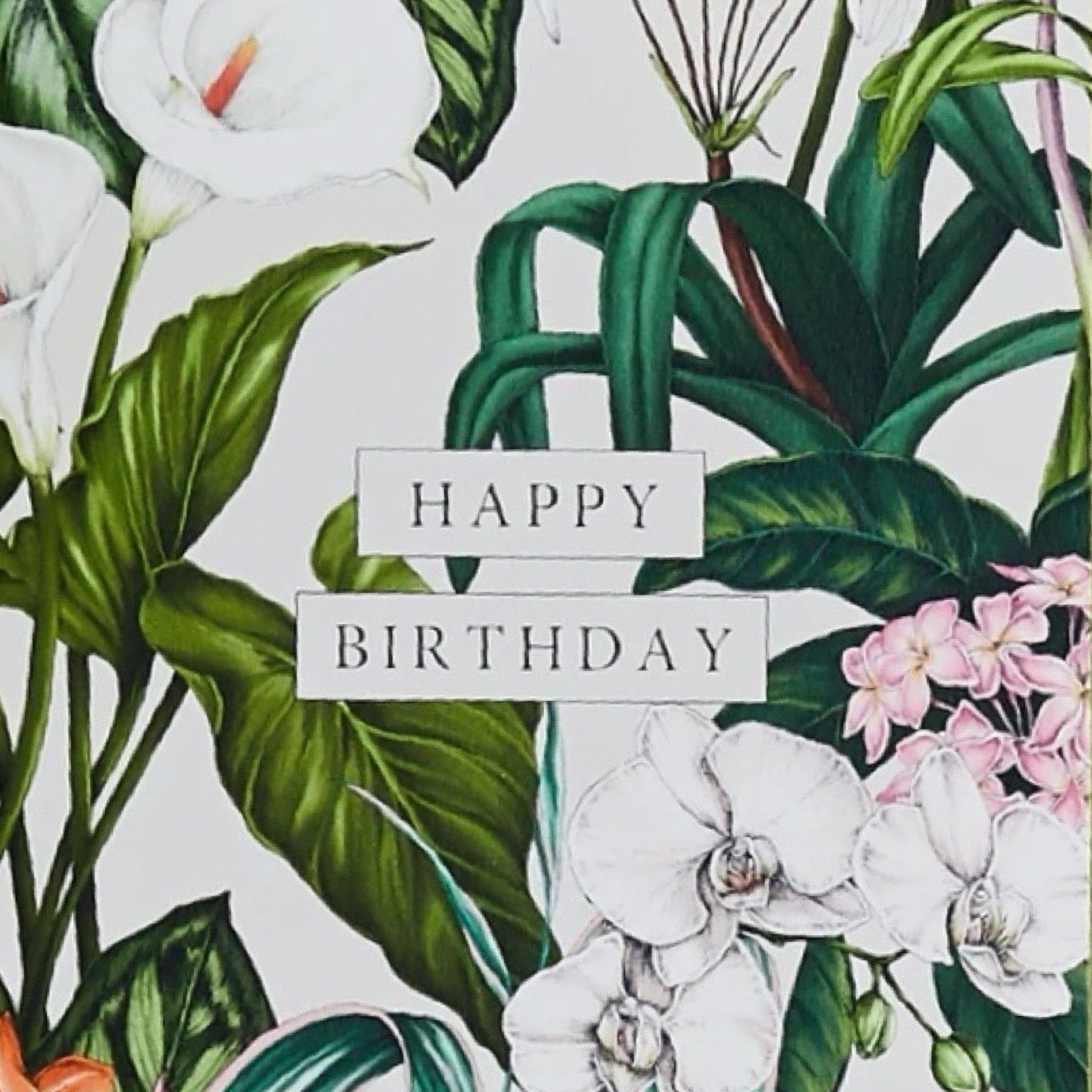 A6 card featuring tropical flowers and foliage and the text 'Happy Birthday' in gold, comes with a green envelope.