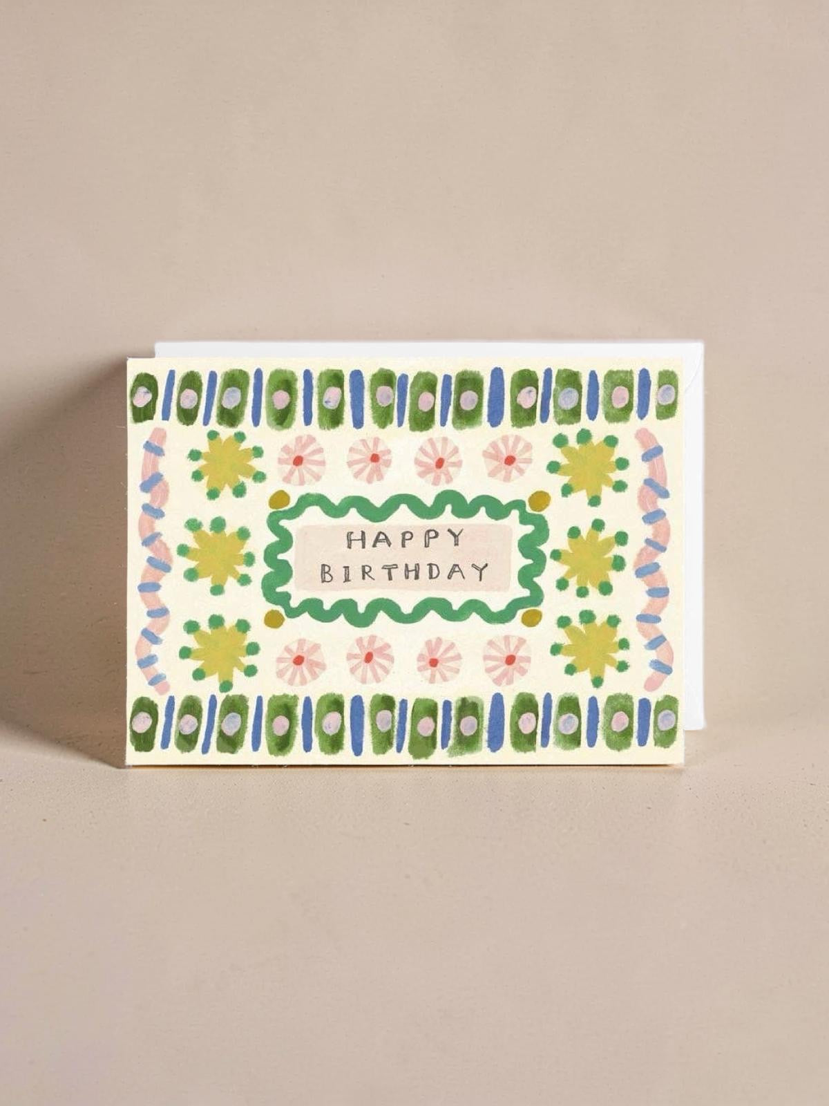 Birthday card with floral design and 'Happy Birthday' text on a beige background.