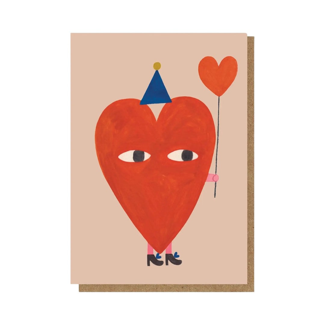 This card features a giant red love heart wearing a blue part hat and black high heeled shoes carrying a red love heart balloon