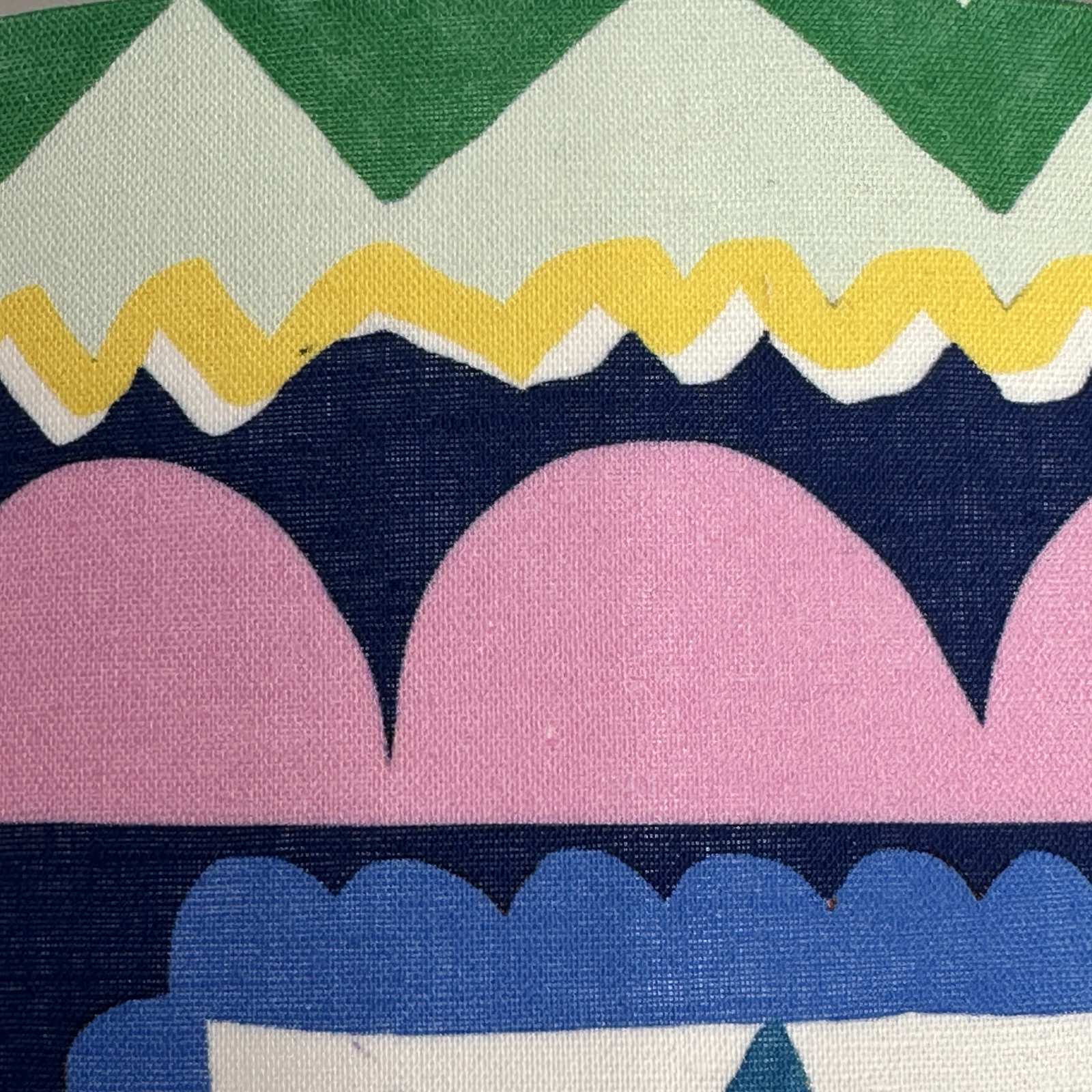 Close-up of fabric with geometric pattern including zigzag, circle, and wavy lines.