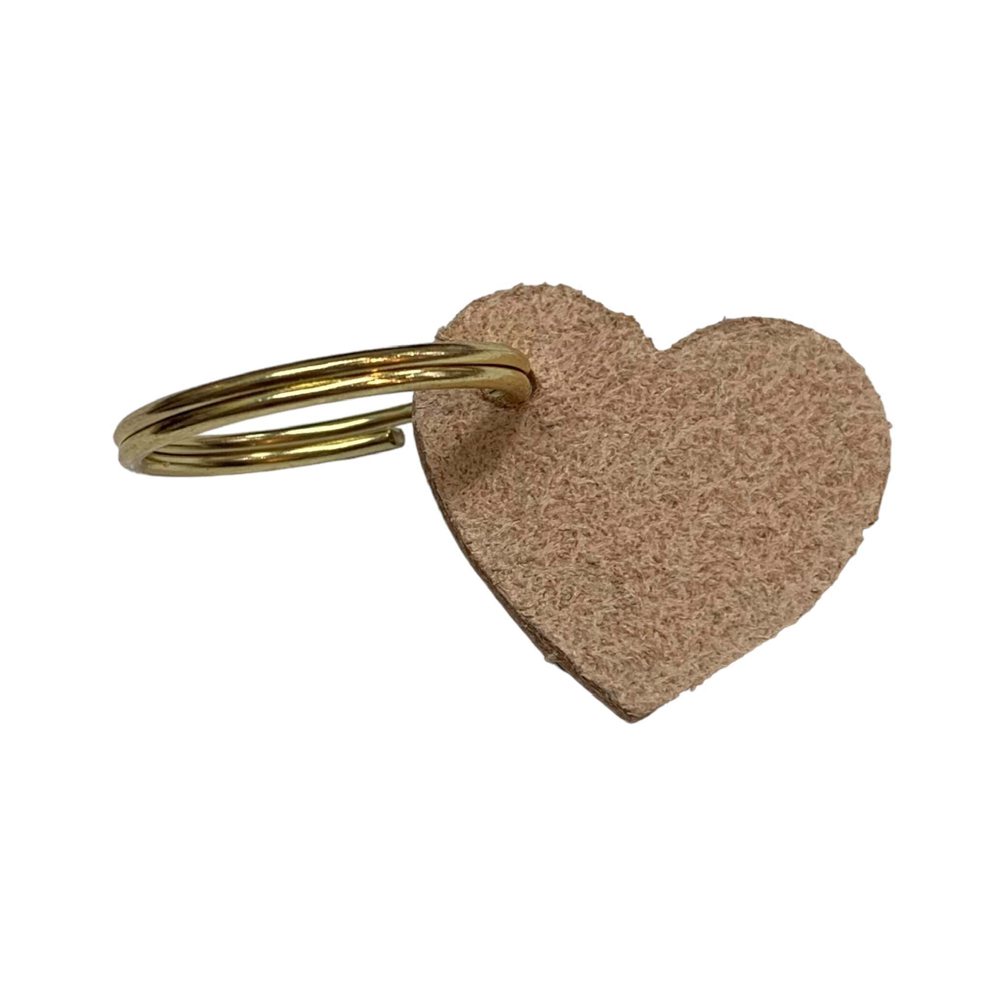 A leather heart-shaped keyring with a brush tone finish and a gold ring.