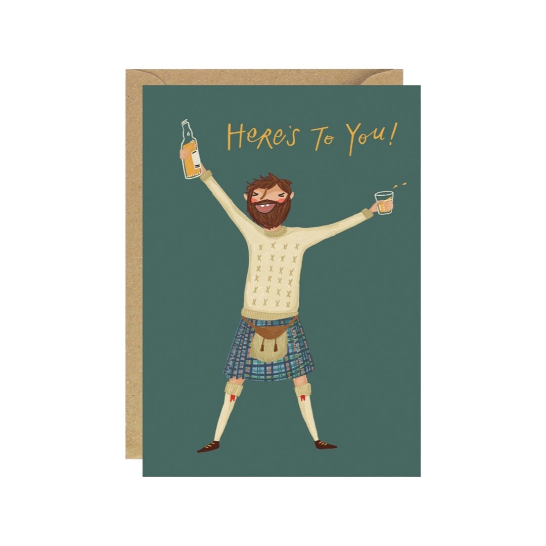 Card of a bearded man in his kilt holding a bottle of whisky in one hand and a glass in the other with the text 'Here's to You'.