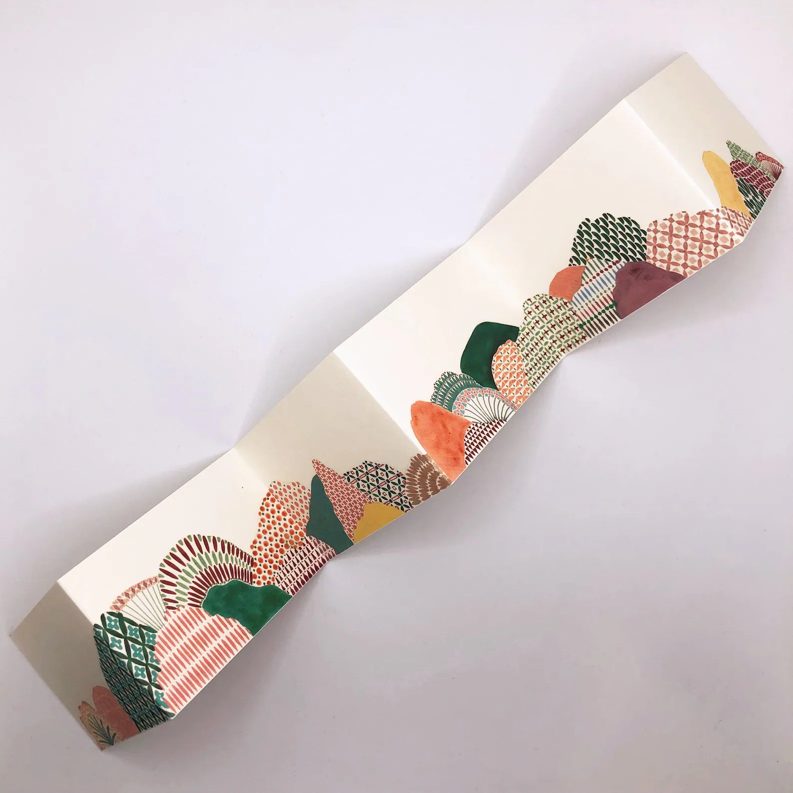 Decorative ribbon with a pattern of geometric shapes on a white background.