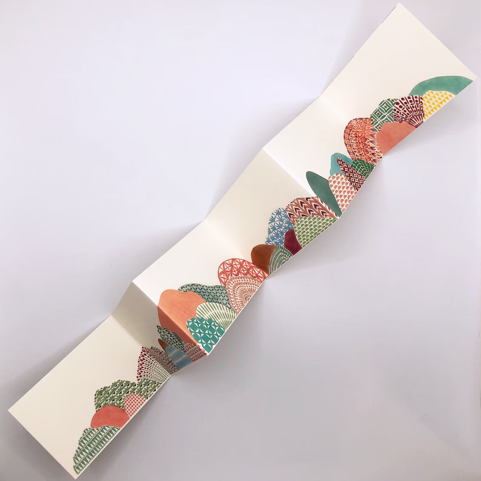 Decorative paper strip with colorful cactus pattern on a white background.
