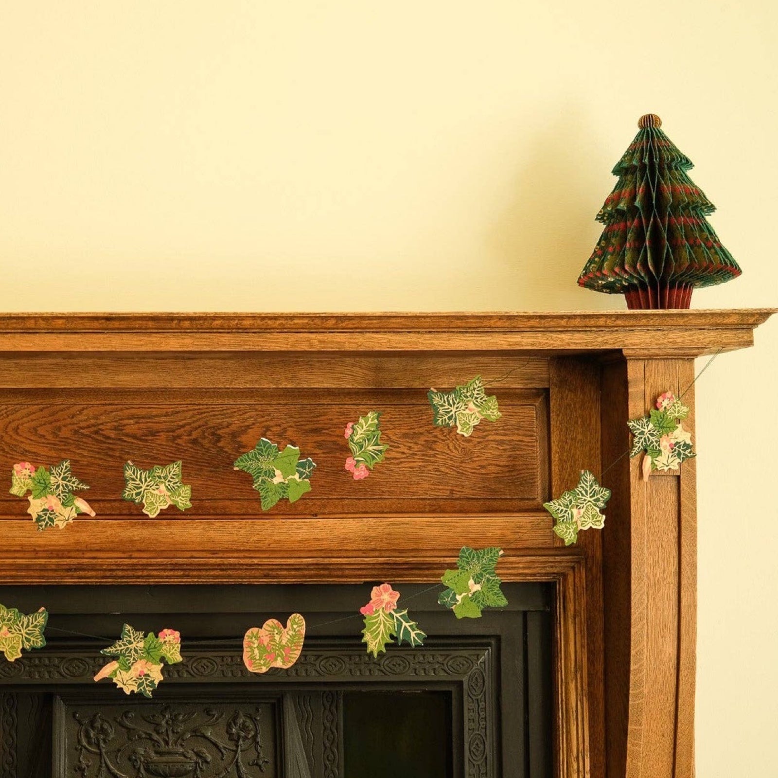 Christmas holly and ivy garland, featuring screen-printed paper bunches of holly and ivy in various green, gold and red designs. 