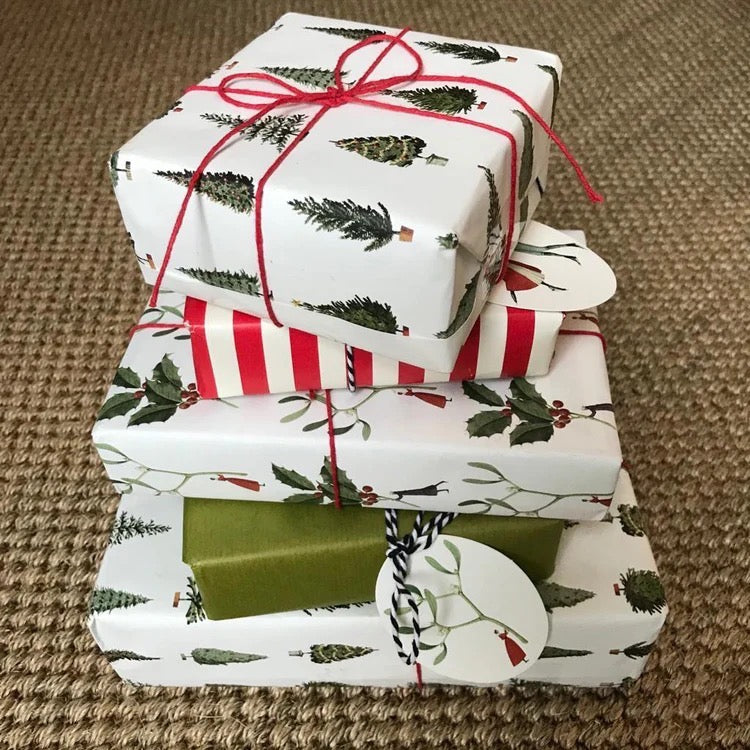 Stack of wrapped Christmas gifts with ribbons on a textured surface.