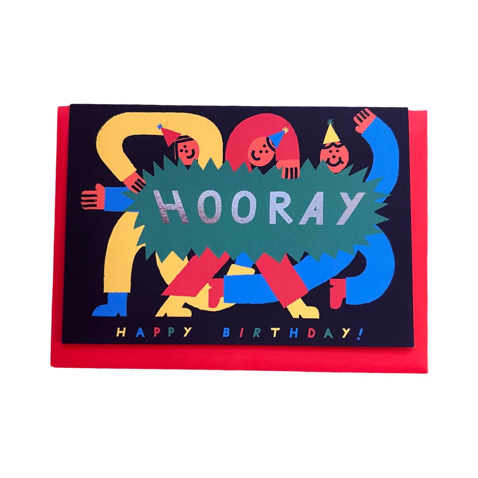 A birthday card with a colourful illustration of stylised figures celebrating, overlaid with a green jagged banner reading 'HOORAY' in glittery silver letters. The card says 'HAPPY BIRTHDAY!' at the bottom and is photographed on a white background with a red card sleeve or backing visible around it.
