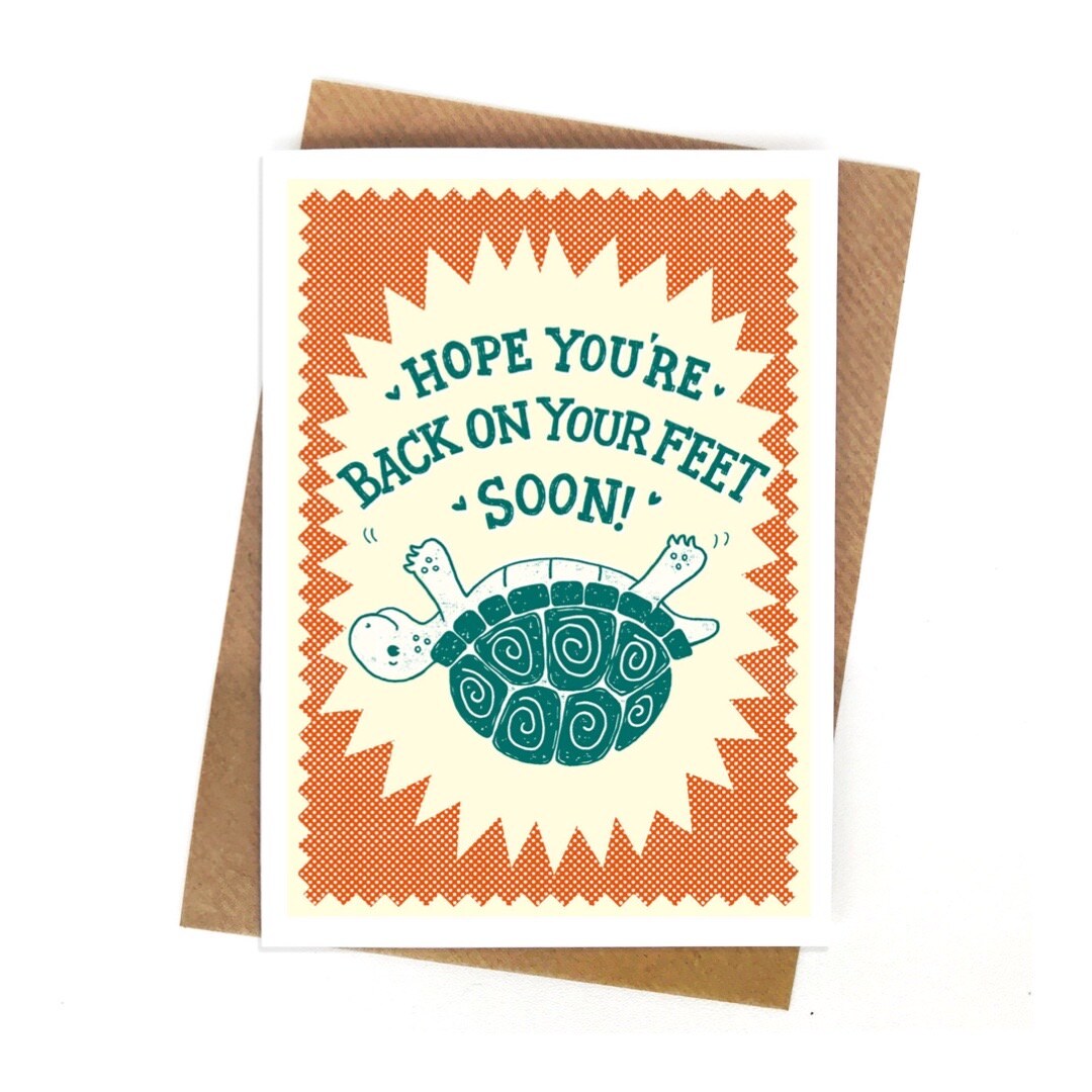 A get well soon card featuring a green turtle lying on his shell and the text hope you're back on your feet soon