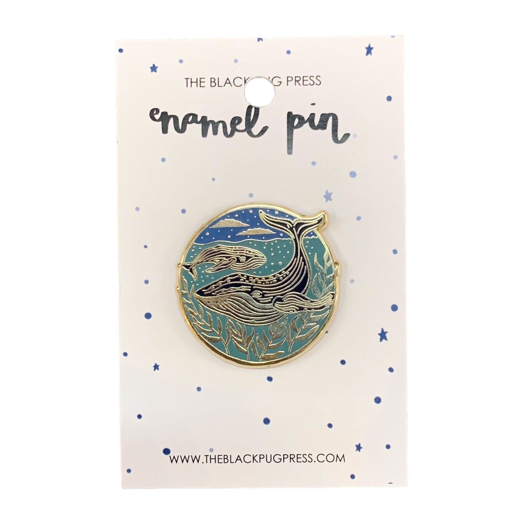 A circular enamel pin badge featuring a mother whale and her calf swimming in the sea at night, with a blue background and stars on backing card.
