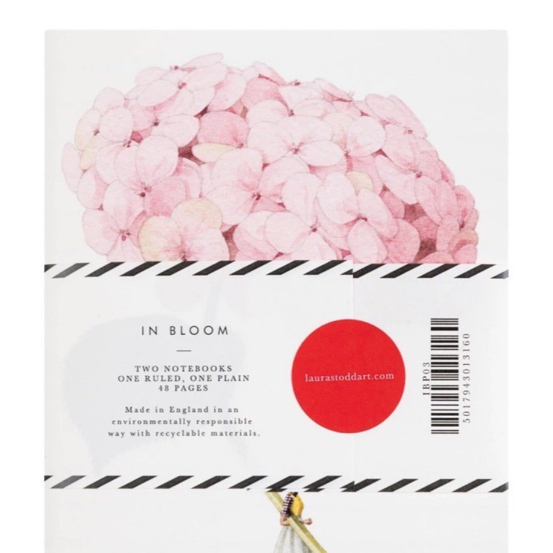 Product packaging for 'In Bloom' notebooks with pink flowers and a red circle on a white background.