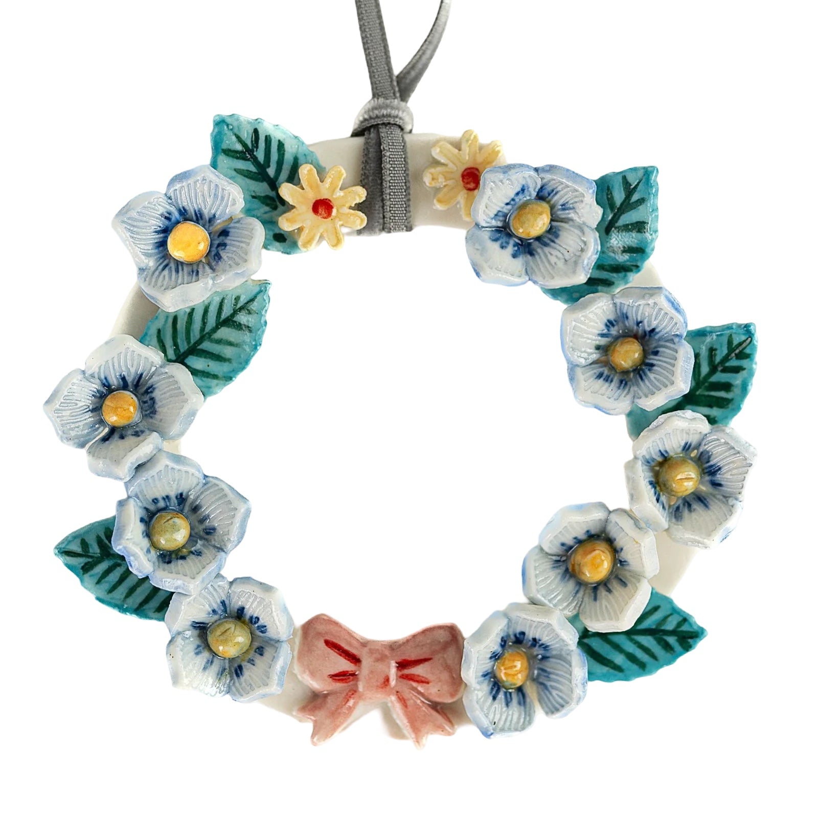 Floral wreath with blue and white flowers, green leaves, and a pink bow on a white background.