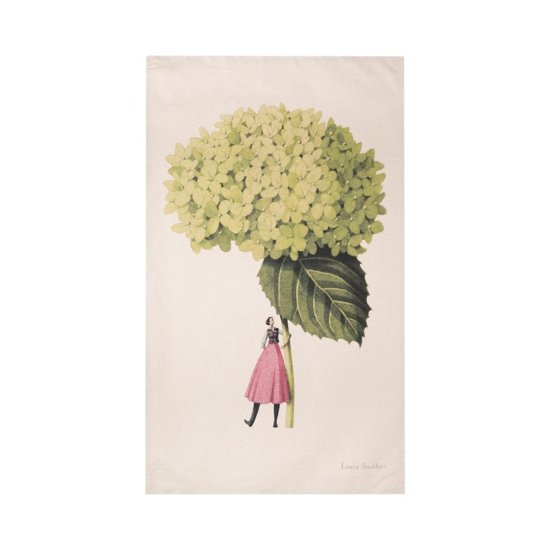 Tea towel featuring an illustration of a lady dressed in a pink dress holding a giant hydrangea.