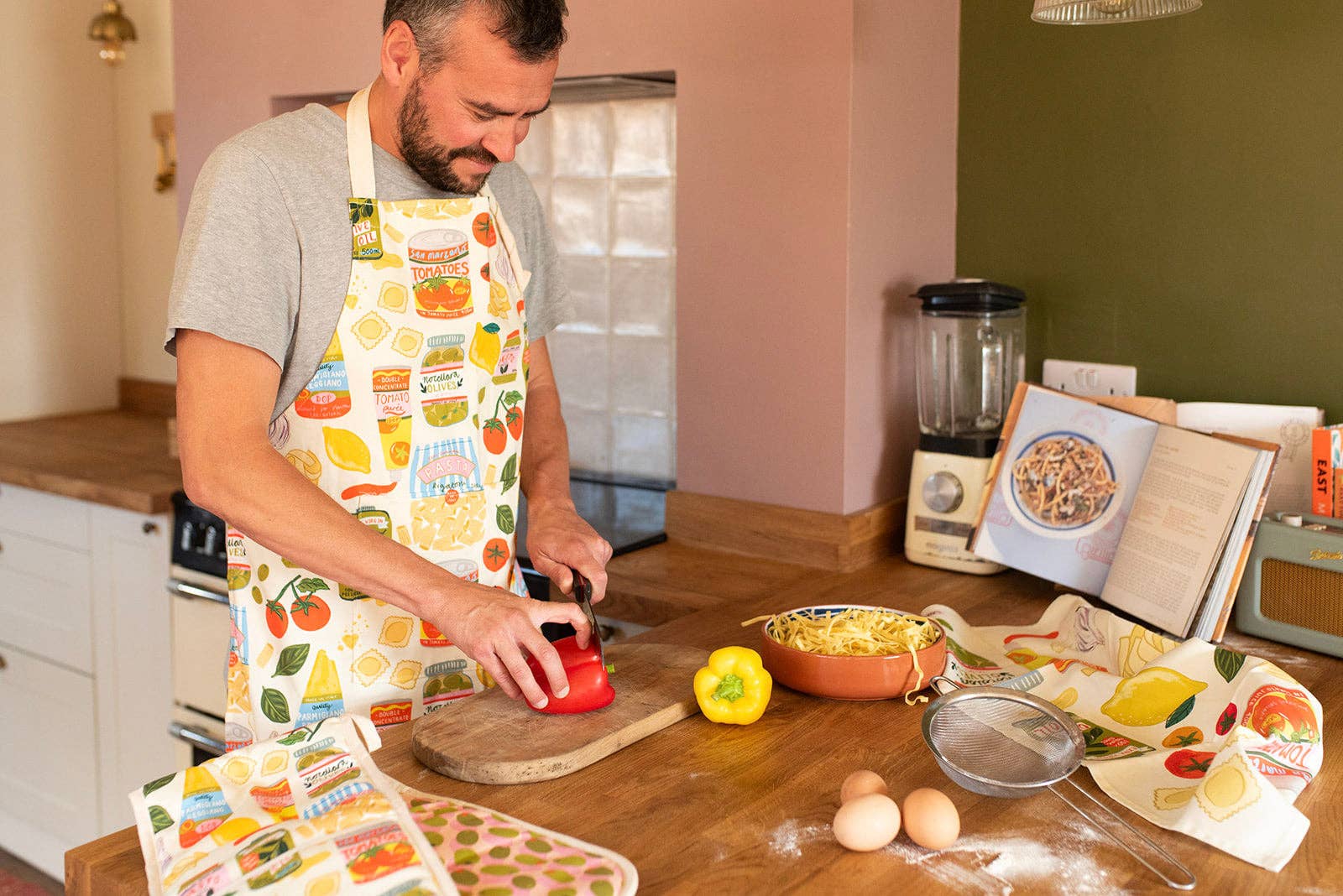 Man in a kitchen preparing food with various items on the counter.
