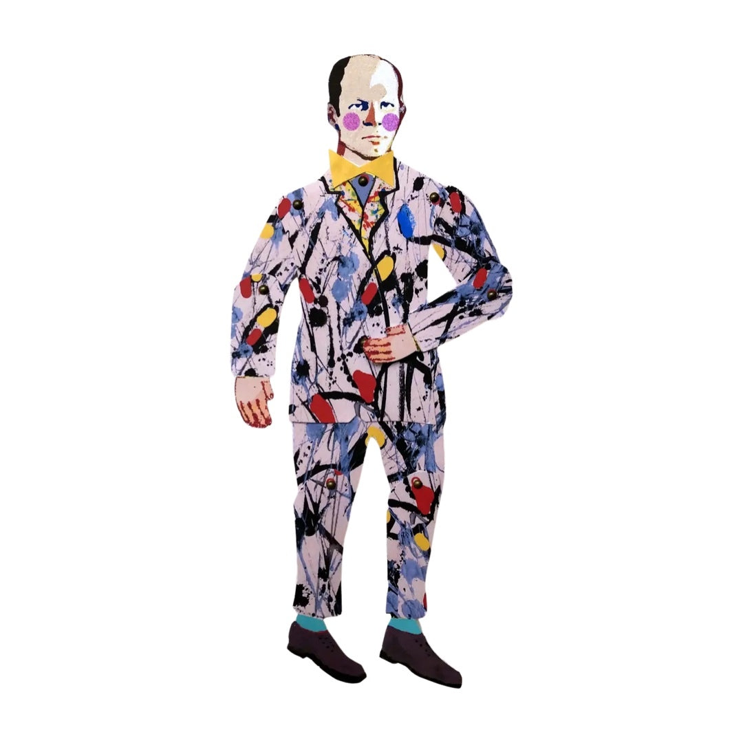 A paper puppet of Jackson Pollock in a white suit with multicolored abstract design, including yellow, red, blue, and black, and a yellow bow tie.