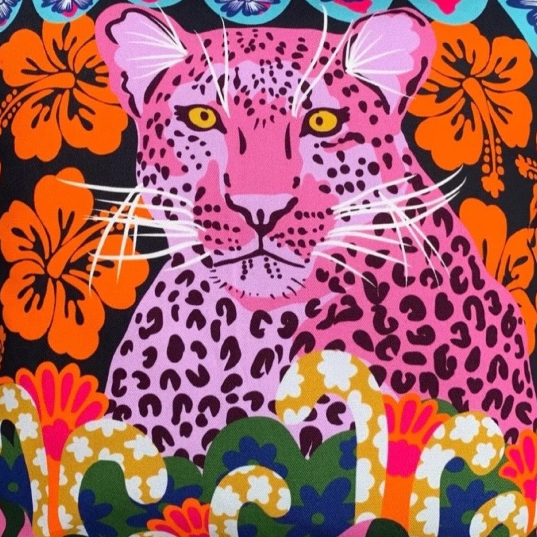Colourful cushion with a pink leopard and floral patterns.