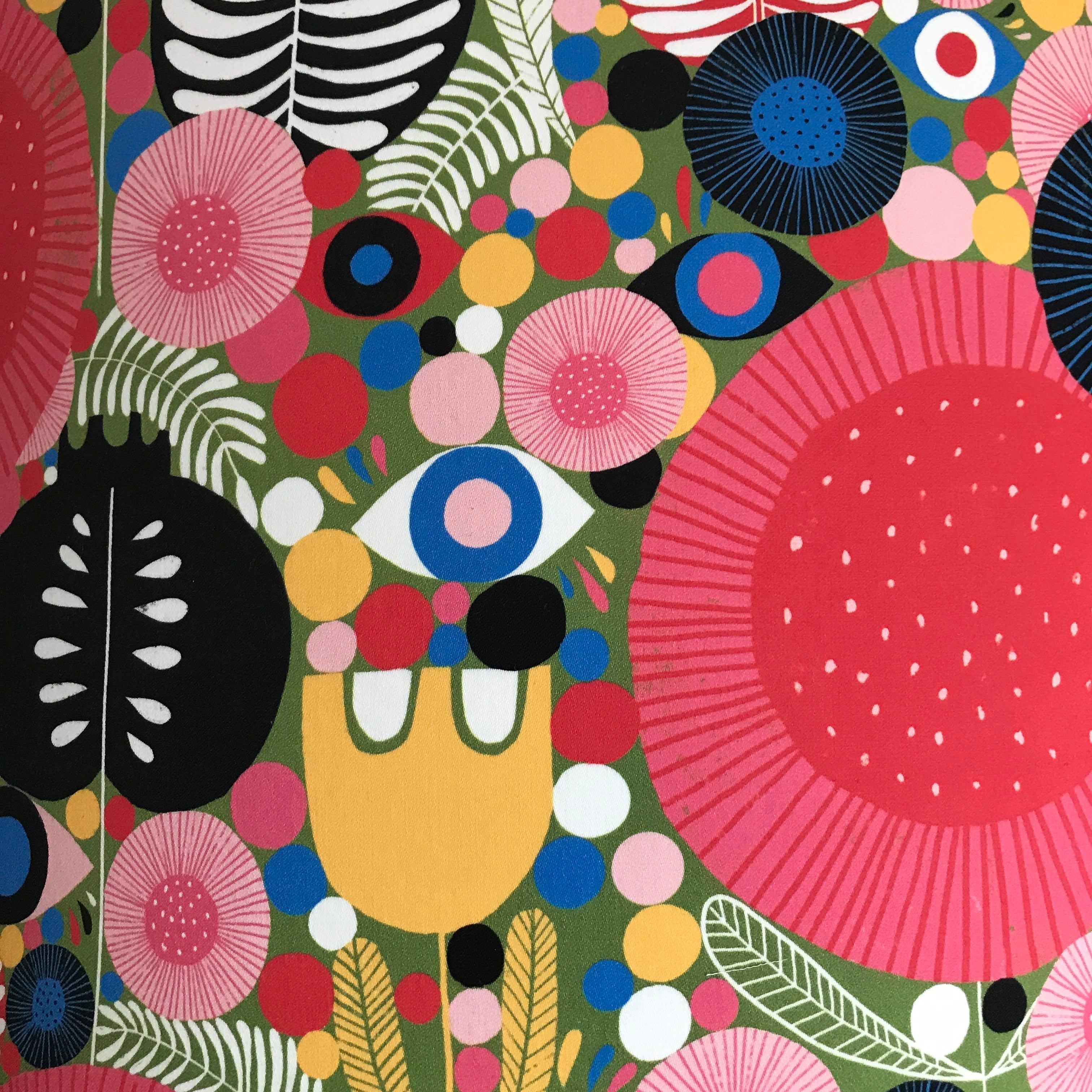 cotton sateen mid-century inspired fabric with various flowers and leaves in reds, white, yellow, red, pinks, greens and blues.