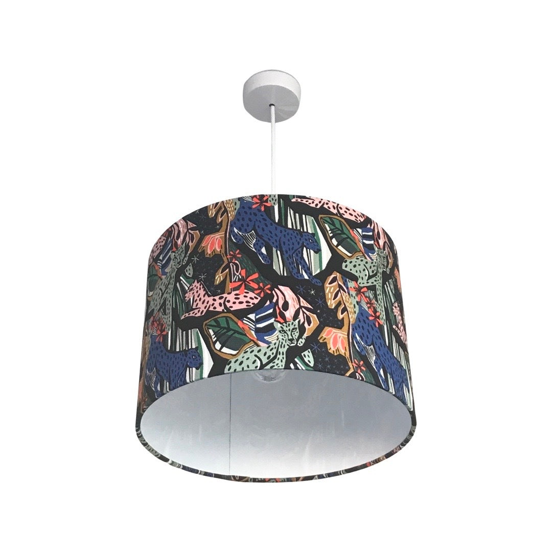 Drum lampshade with pink, blue and green jungle cats and jungle foliage against a black background