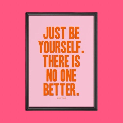 Framed poster with motivational quote 'Just be yourself. There is no one better.' by Taylor Swift on a pink background.