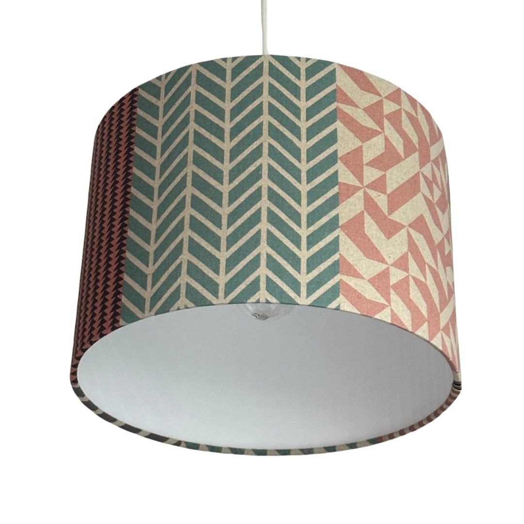 Handmade drum lampshade with pink, grey, navy, and cream geometric designs.
