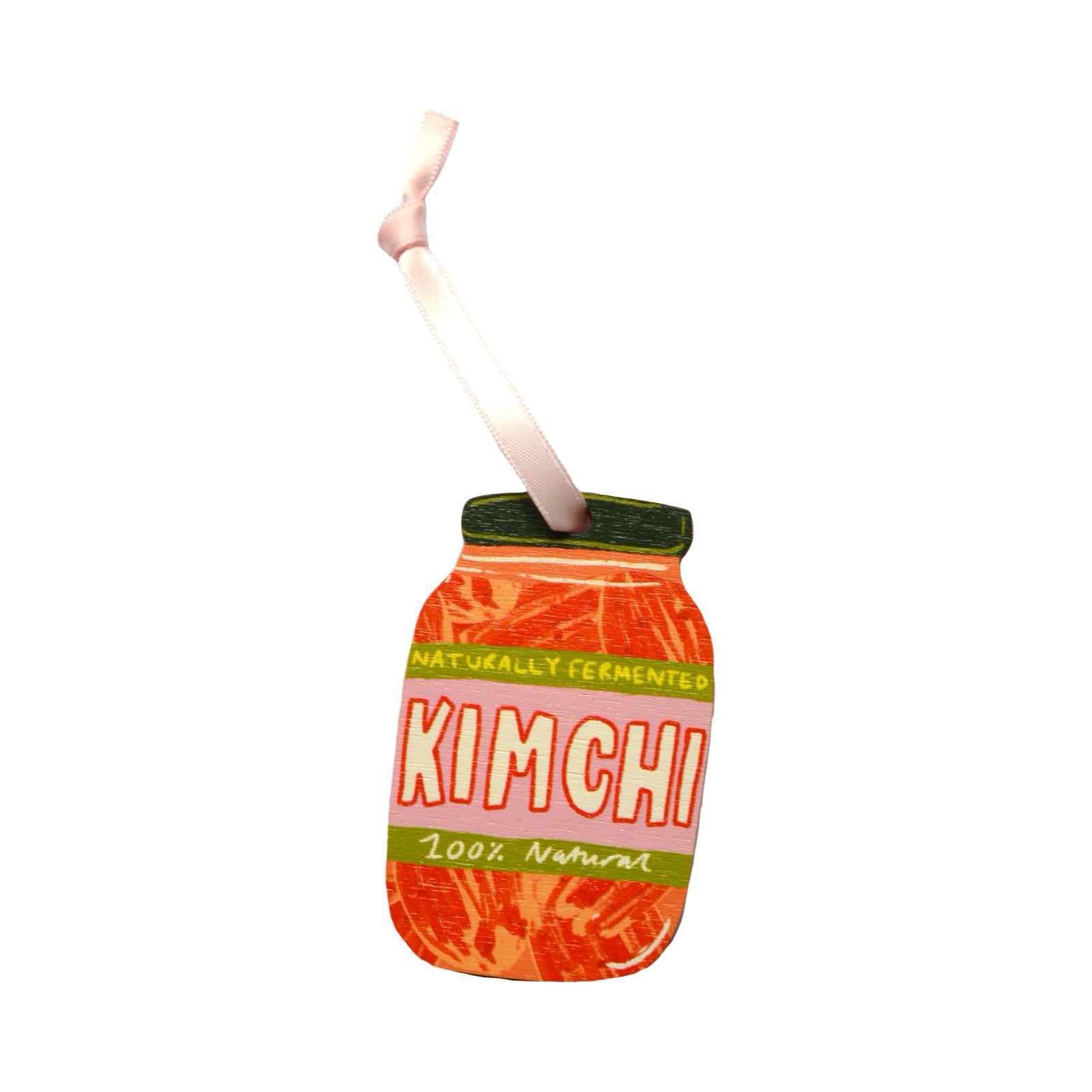 Decorative kimchi jar with straw on a white background.