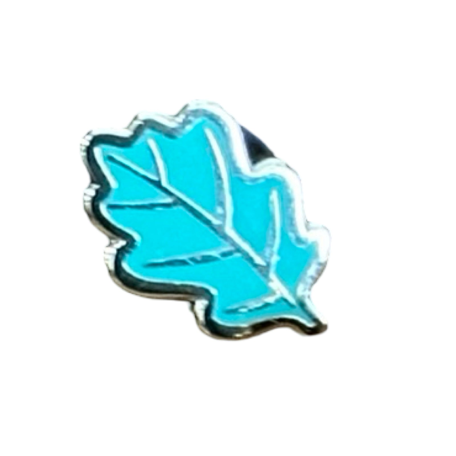 A set of three leaf-shaped enamel pin badges, one green, one orange and one lilac.