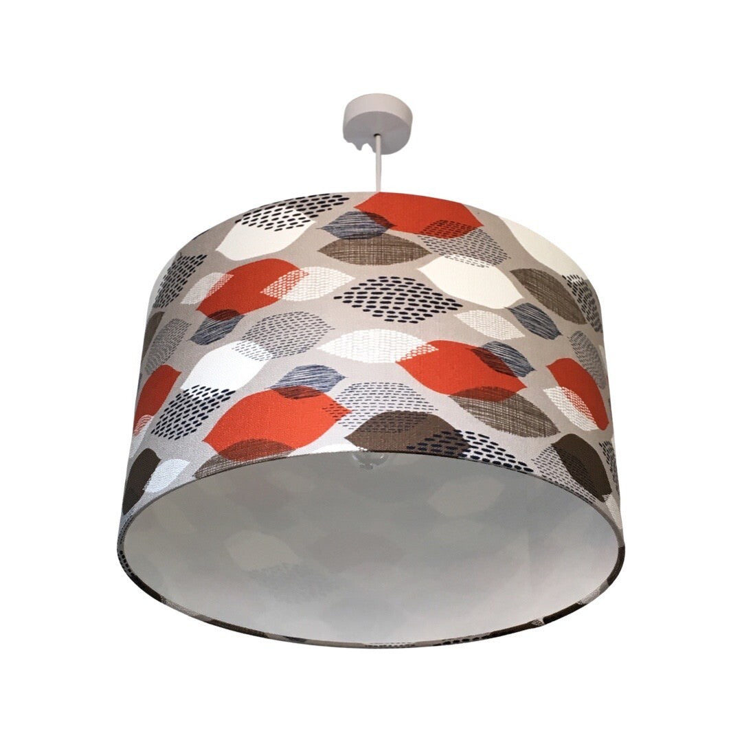 Drum lampshade with a grey background with brown, orange and white leaves.