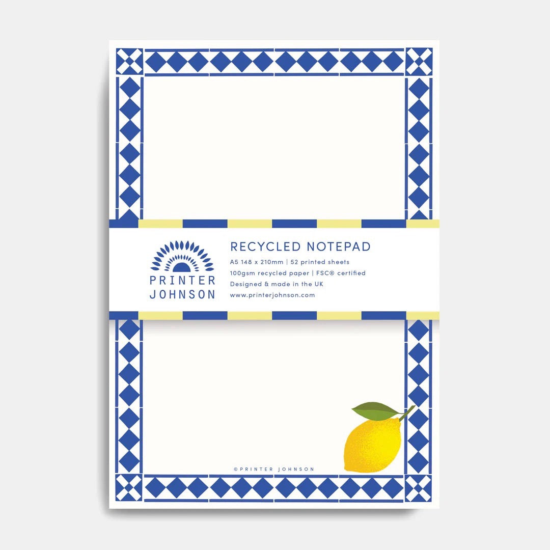 Recycled notepad with blue geometric border and lemon illustration on a white background.