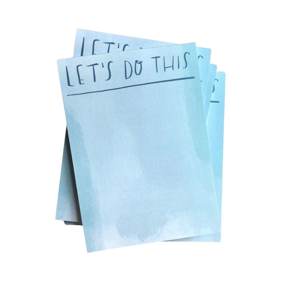A stack of pale blue A6 notepads with the text 'Let's Do This' written on the top sheet.