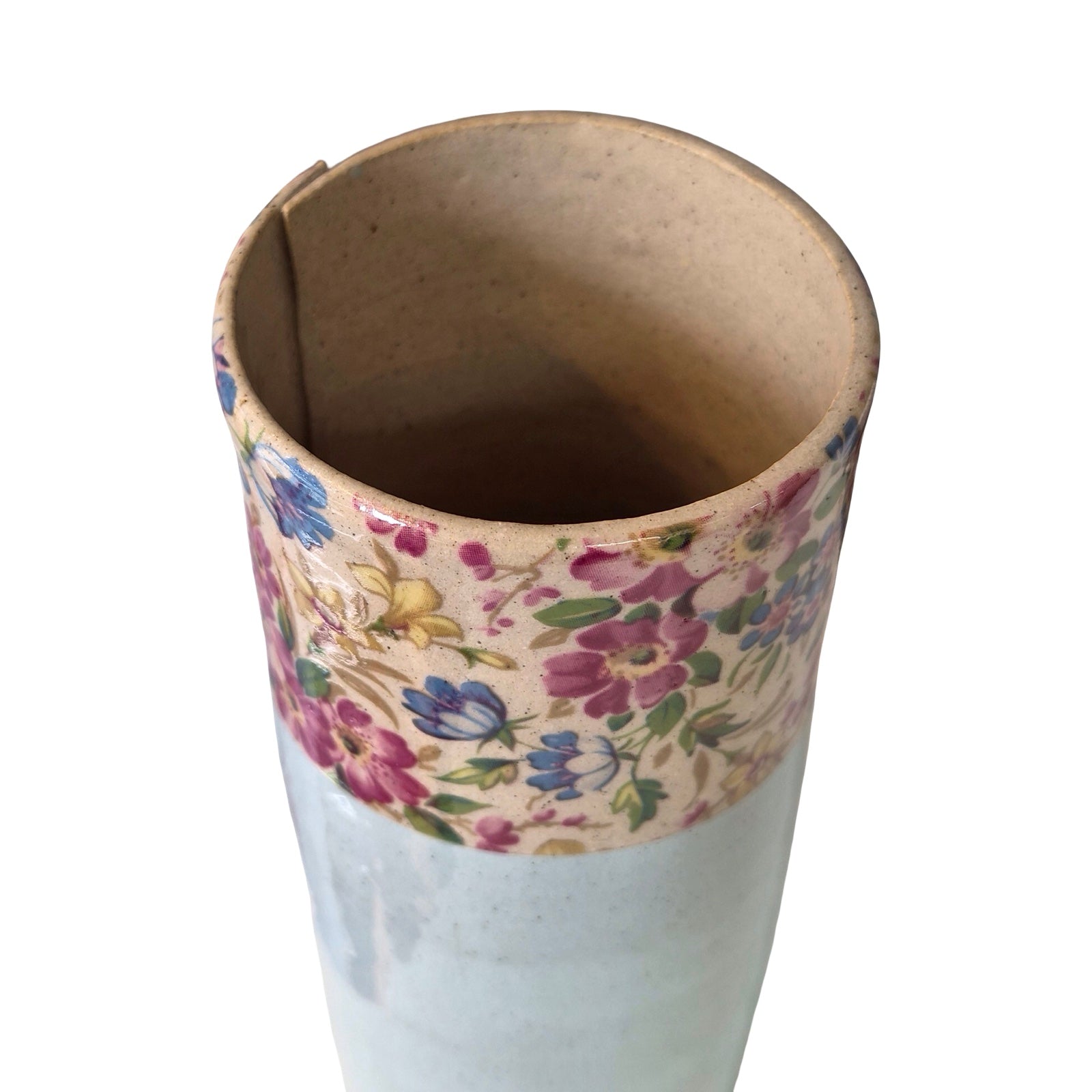 Cylindrical vase with floral patterned top and blue bottom on a white background.