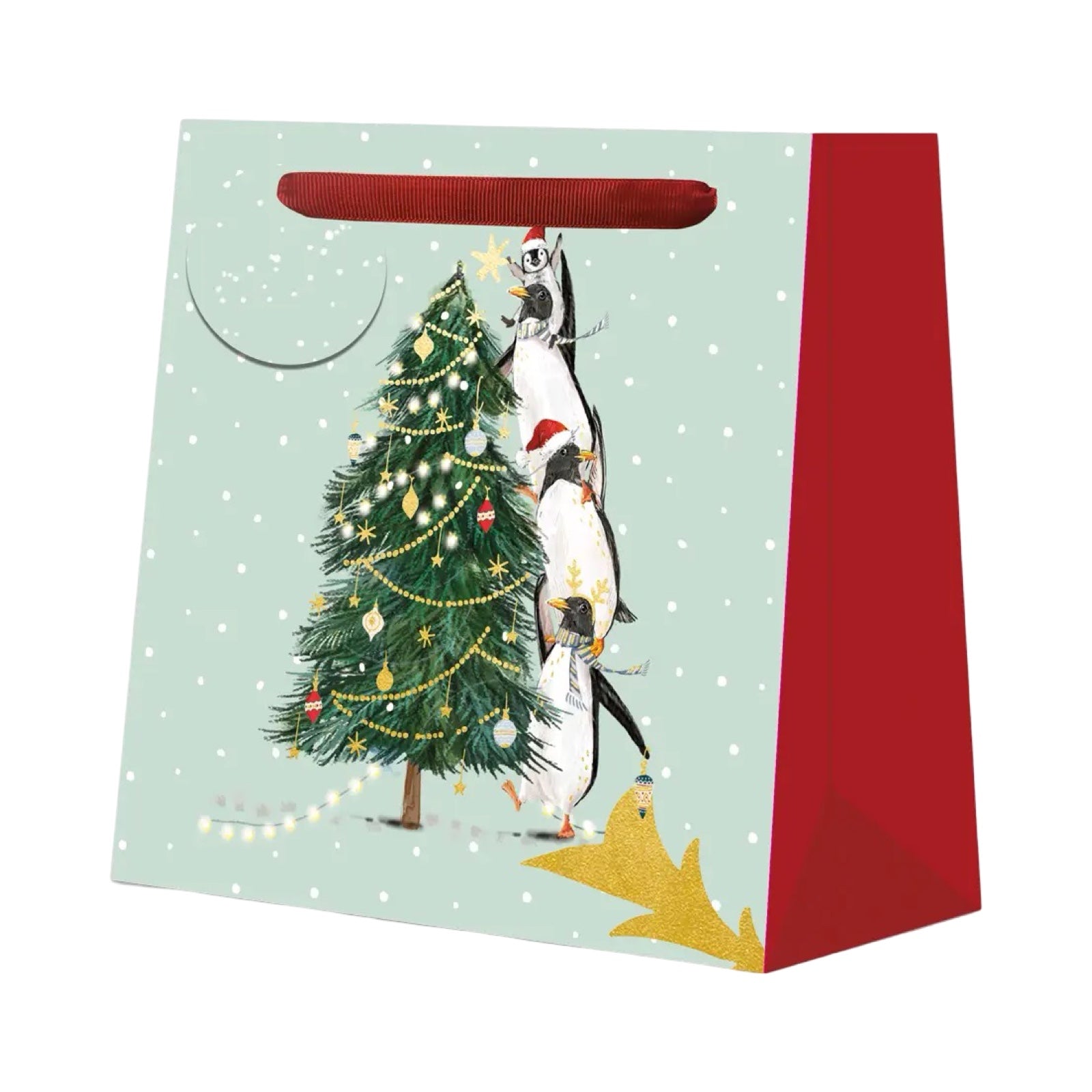 Gift bag with penguins and a Christmas tree design on a light green background