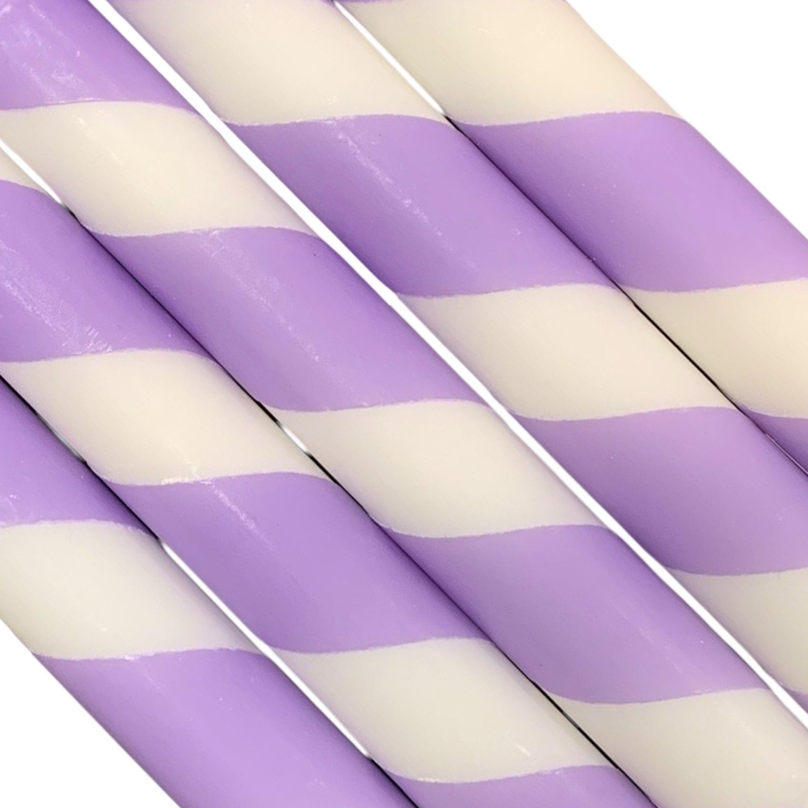 A row of 5 handmade dinner candle with lilac and white diagonal stripes.