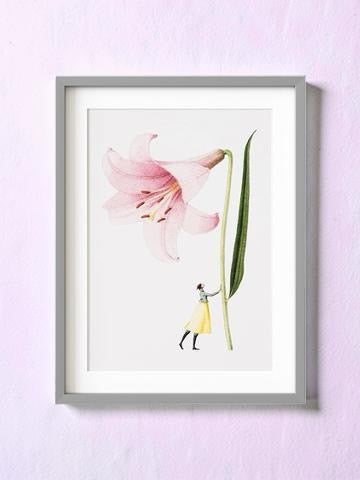 Framed artwork of a pink flower and a small figure on a light purple wall.