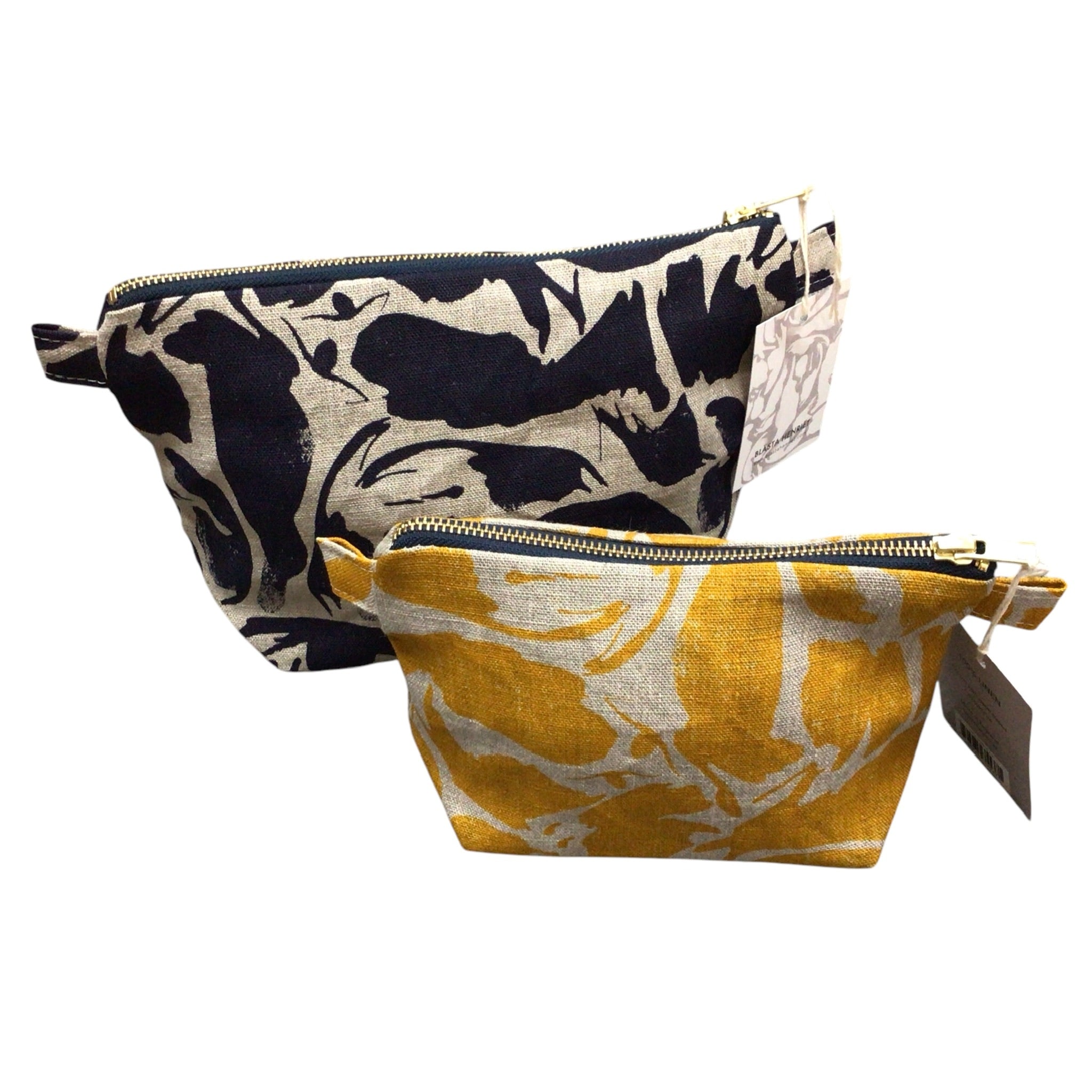 A navy patterned large linen toiletry bag with a yellow patterned small linen toiletry bag sitting infront.