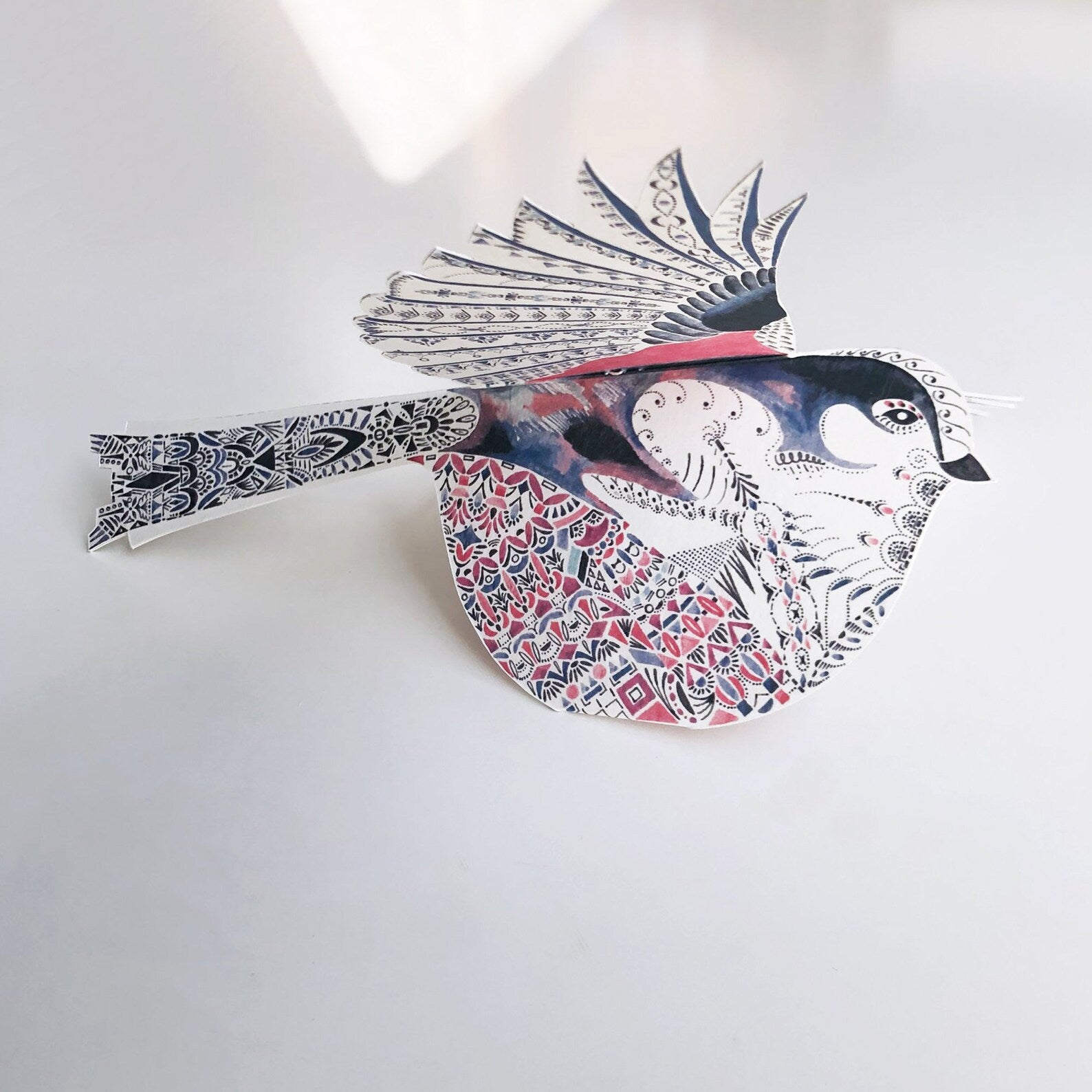 Decorative wall art of a stylised bird with intricate patterns on a white background.