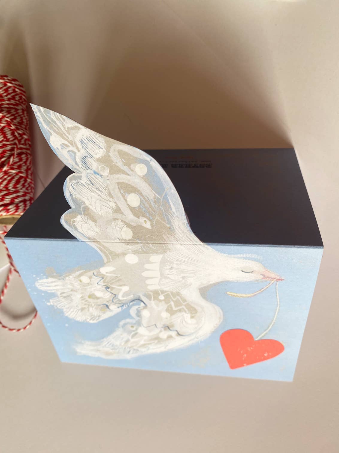 Card with a dove and heart design on a plain background.