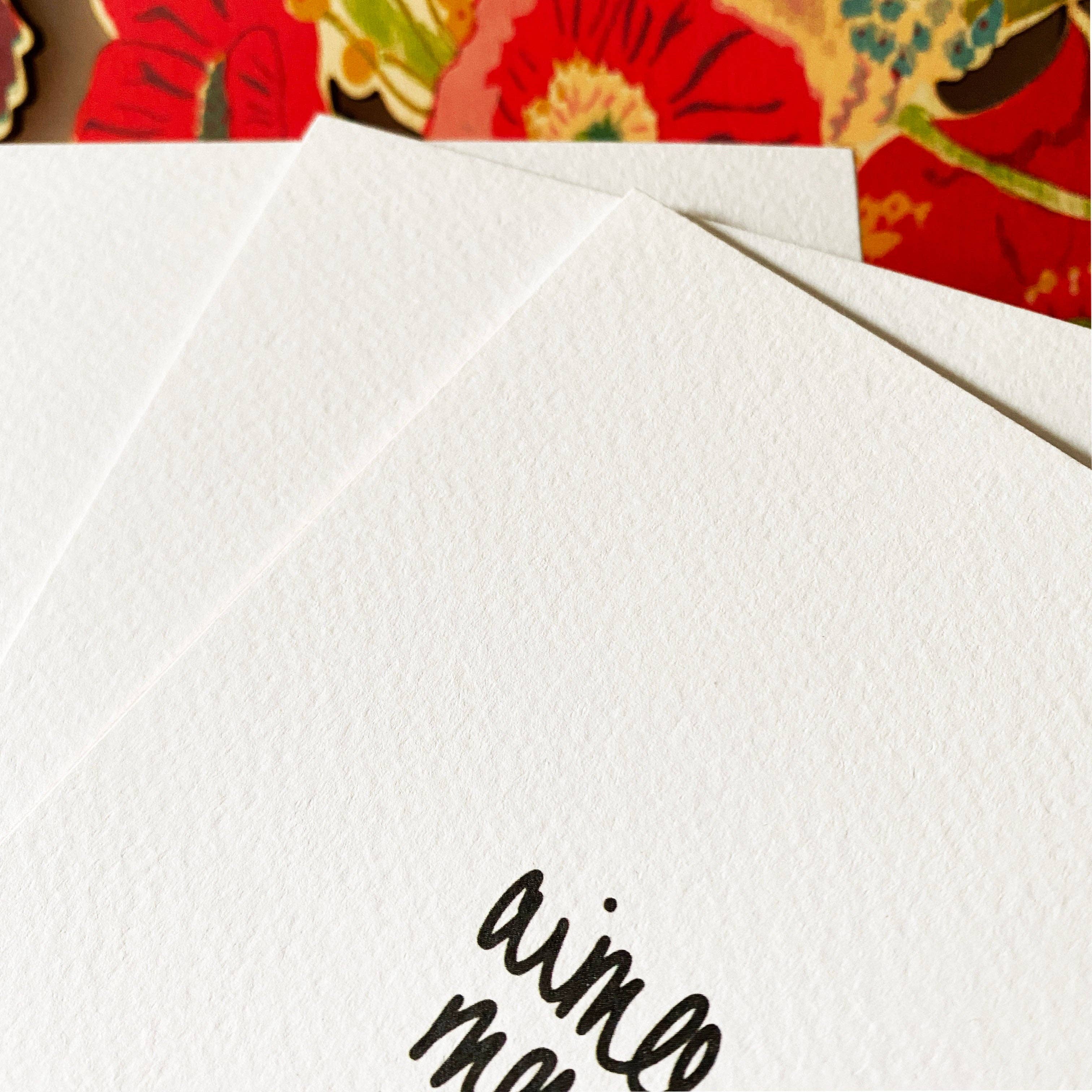 White card with 'aimee' printed on it, placed on a colorful floral background