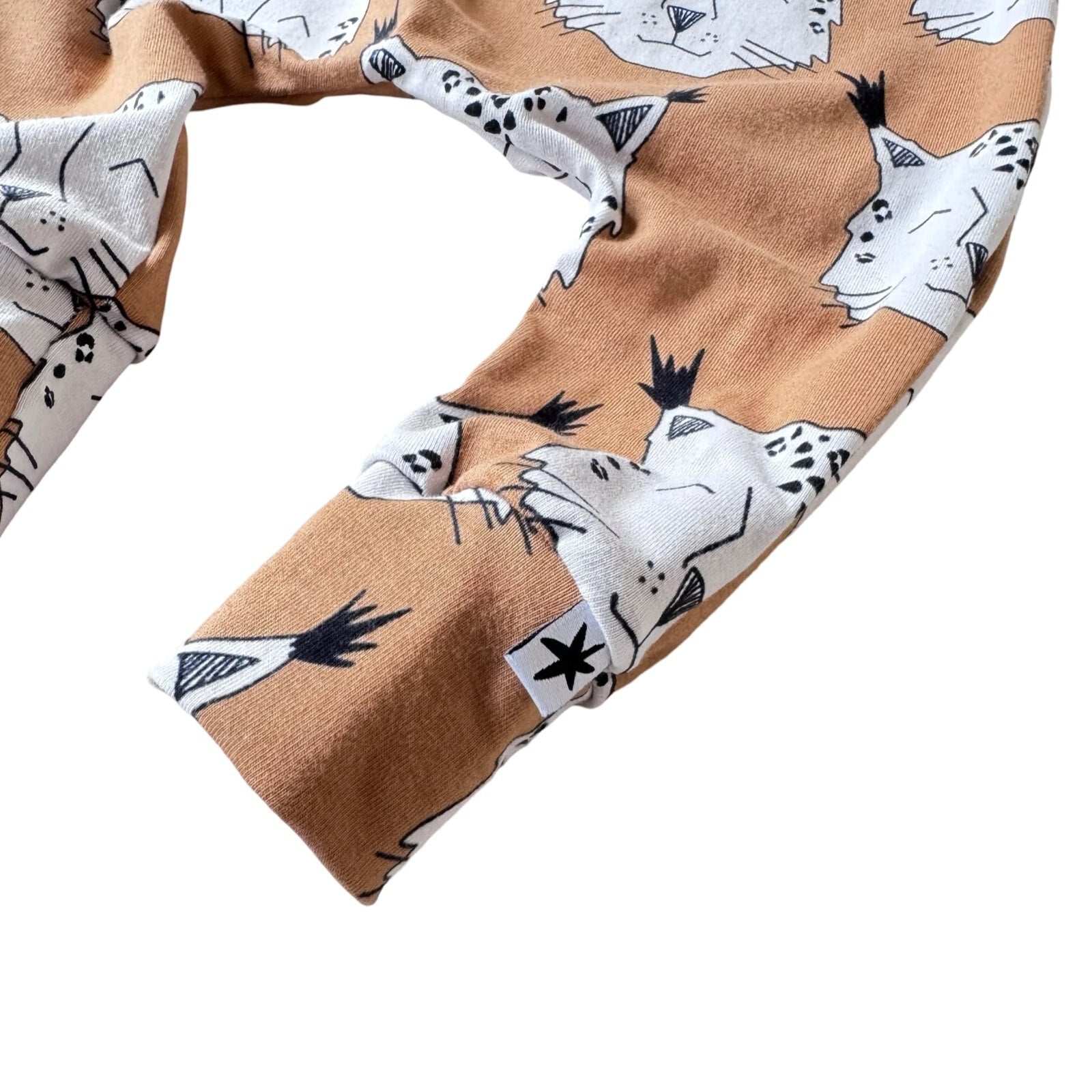 Brown harem leggings with a lynx pattern, featuring a stiff waist elastic and finished with cuffs.