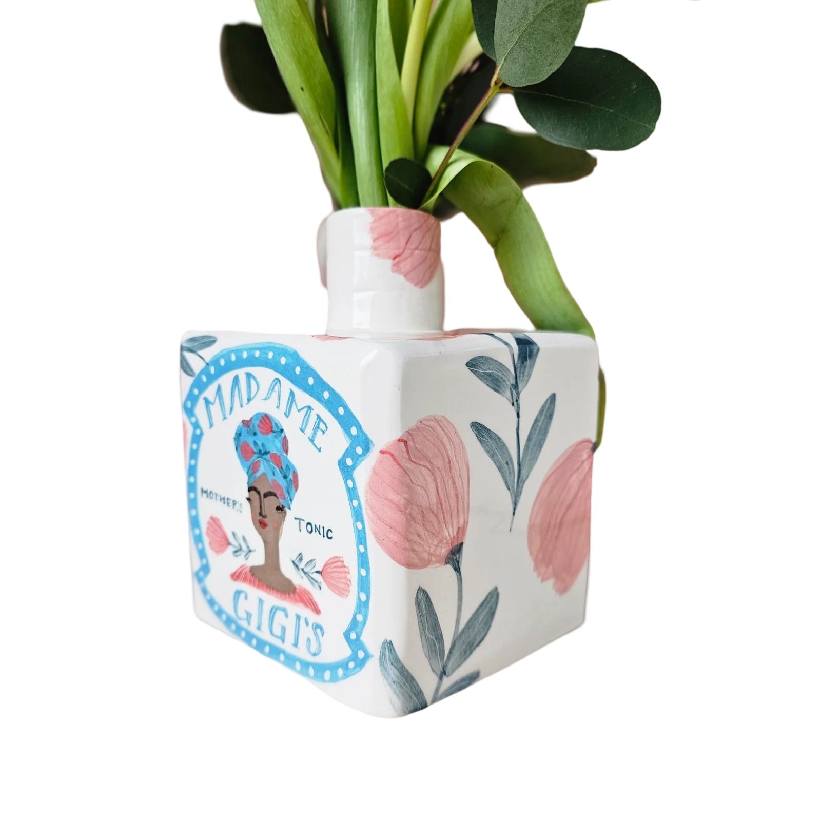 White ceramic vase with pink flowers and green leaves and an illustration of 'Madame Gigi'.