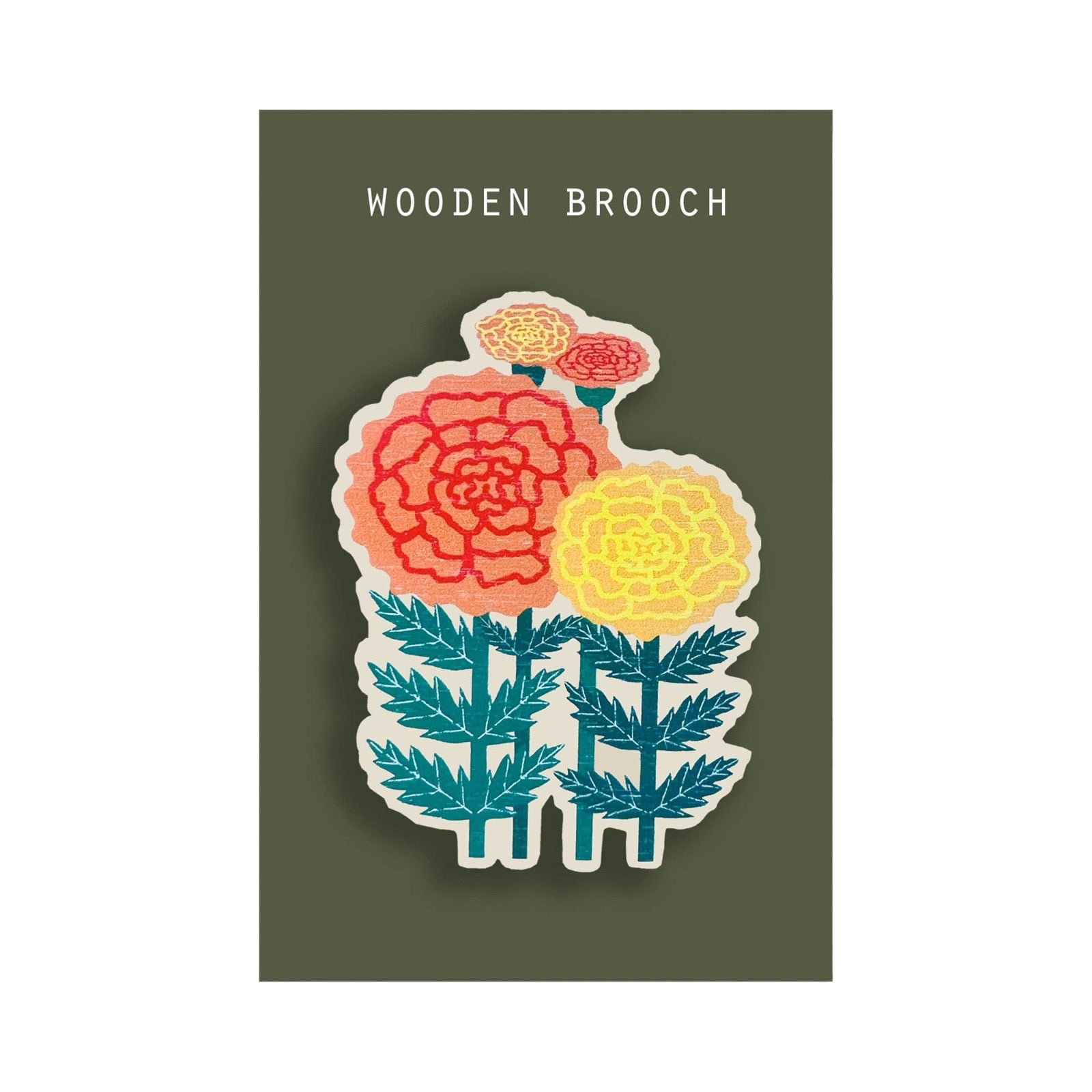 A wooden brooch featuring a stylised marigold design with red, yellow, and orange flowers and teal leaves, mounted on a dark olive green backing card labeled 'WOODEN BROOCH'.