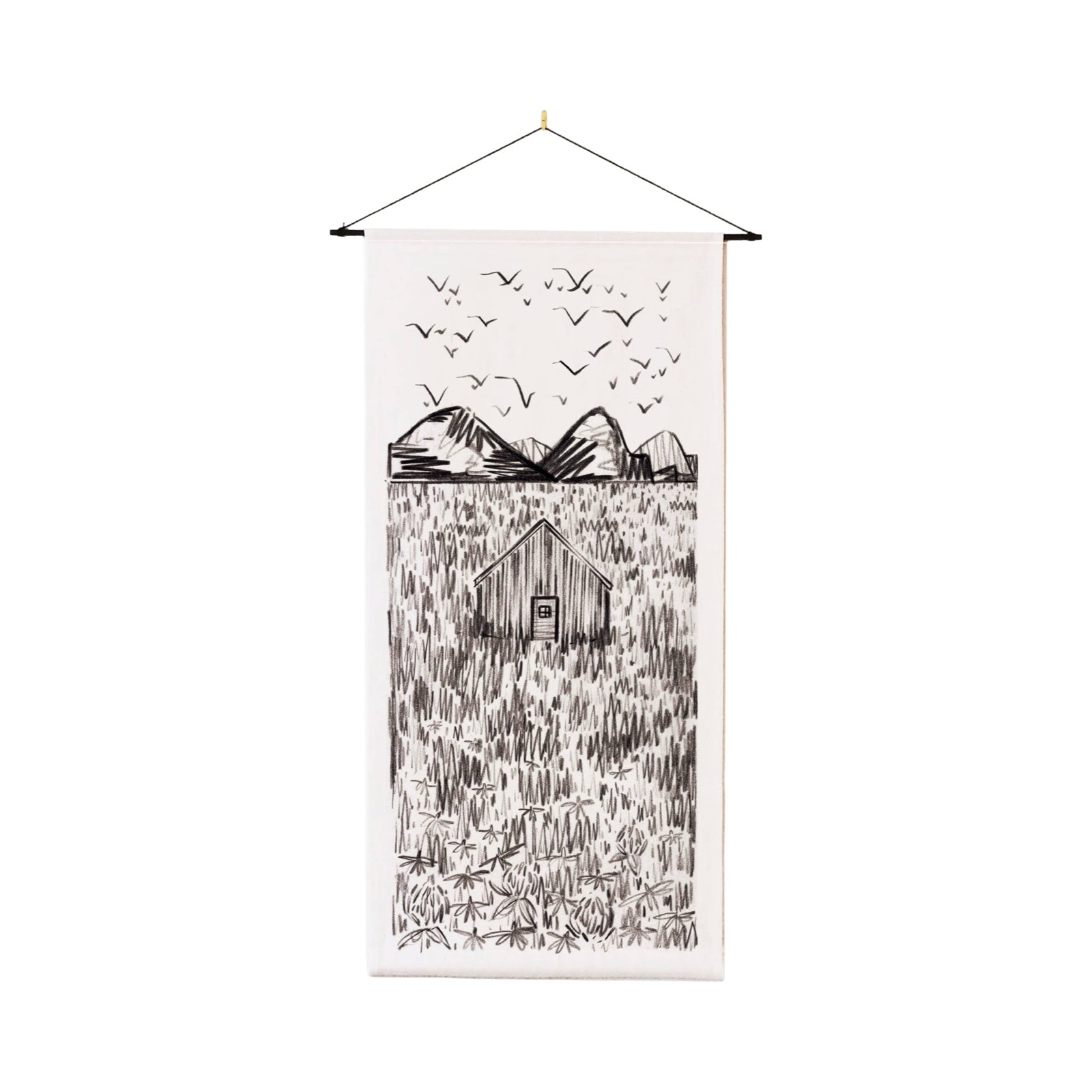 A cream coloured cotton wall hanging with an illustration of a hidden cabin, with mountains behind, birds flying overhead and a meadow in the foreground, all in black ink,
