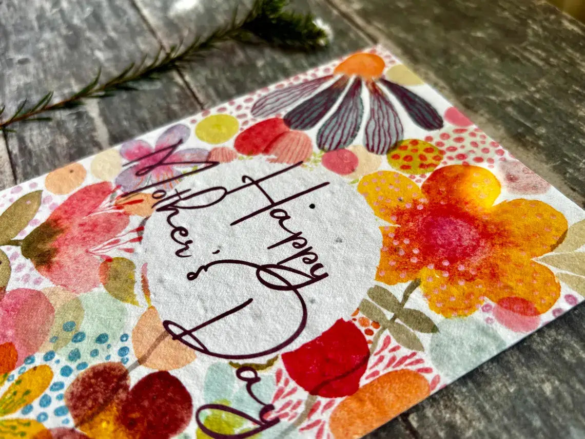 Colourful card with floral designs and 'Happy Mother's Day' text on a wooden surface.