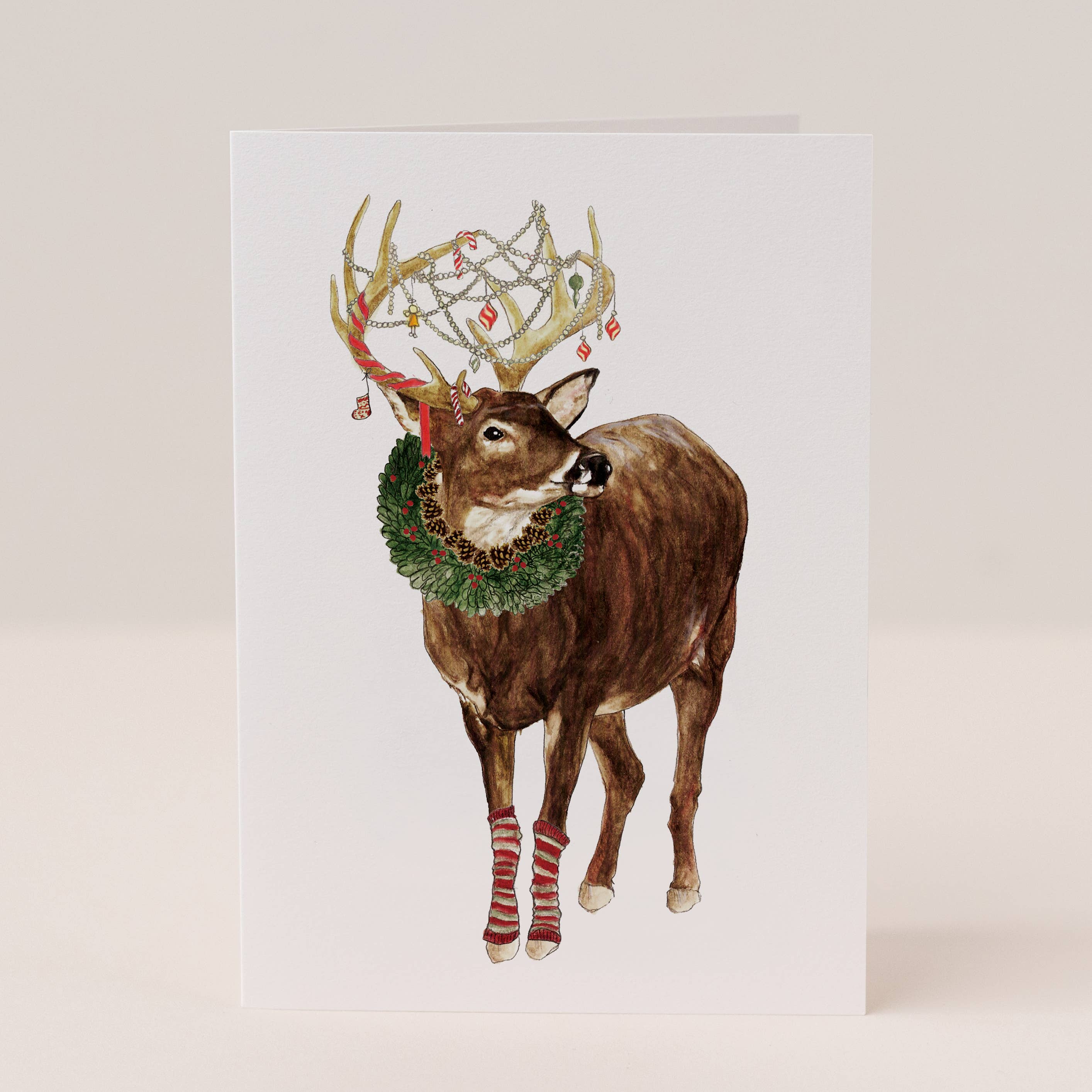 Illustration of a deer with festive antlers and wreath on a white background.