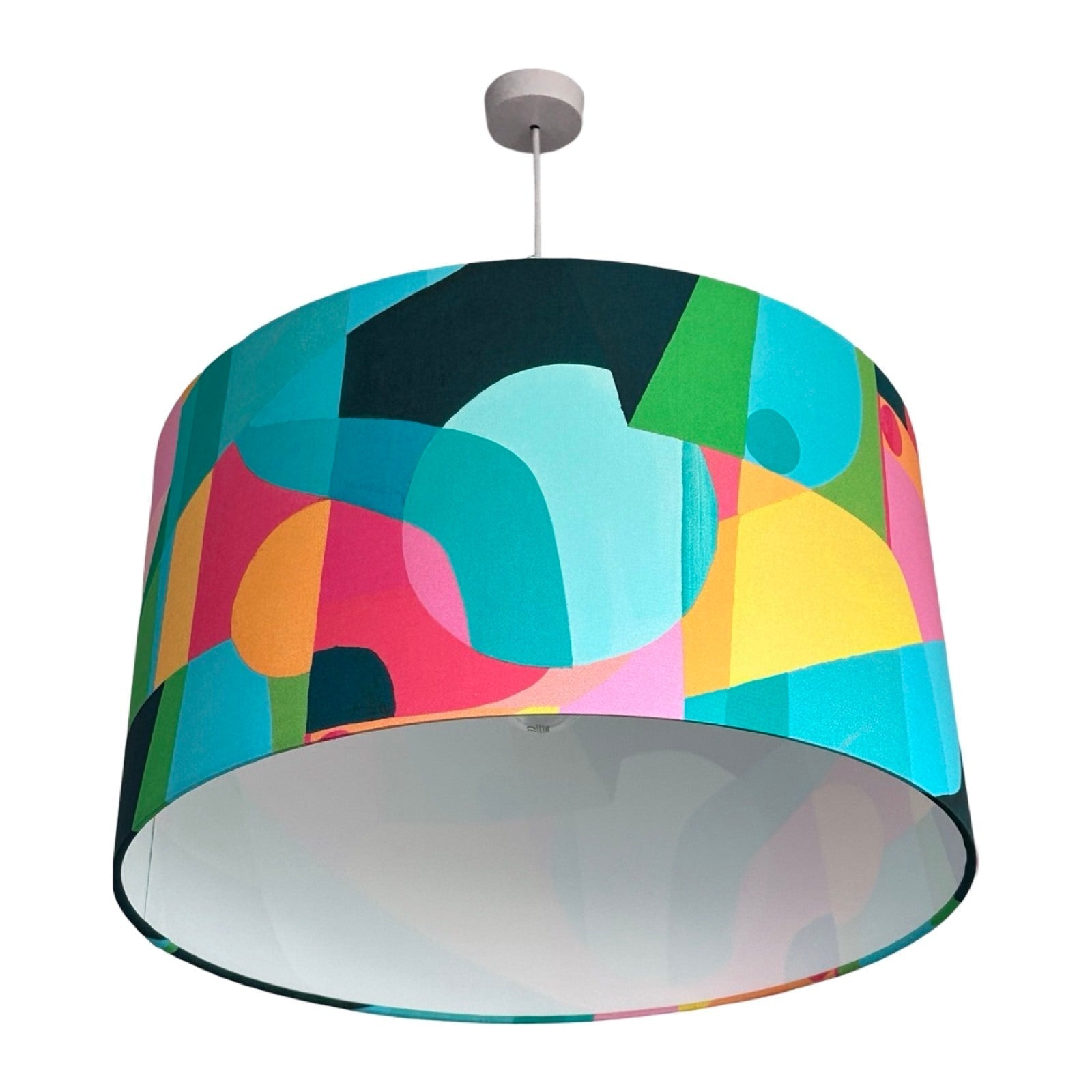 Drum lampshade covered in bright cotton fabric with abstract geometric shapes in turquoise, navy, pink, yellow and green