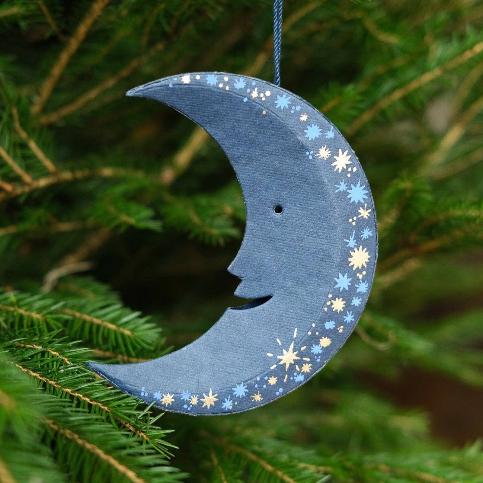 This gorgeous navy, blue and gold moon-shaped decoration has a matching 10cm cotton loop for hanging. Each moon decoration is made from 100% recycled paper, screen-printed by hand and moulded into a durable board decoration.