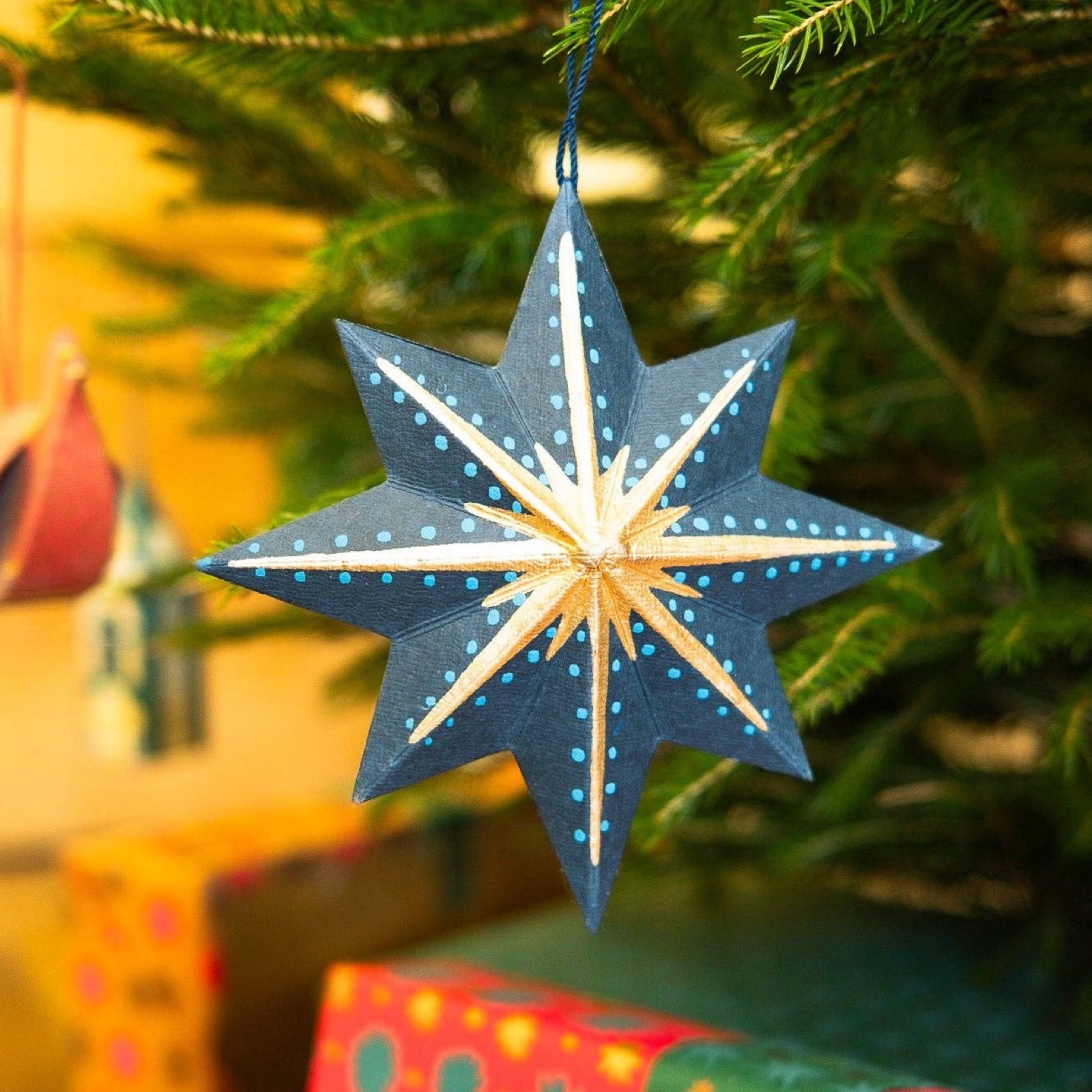 This festive navy, gold and teal star decoration has a matching 10cm cotton loop for hanging. Each star decoration is made from 100% recycled paper, screen-printed by hand and moulded into a durable board decoration.