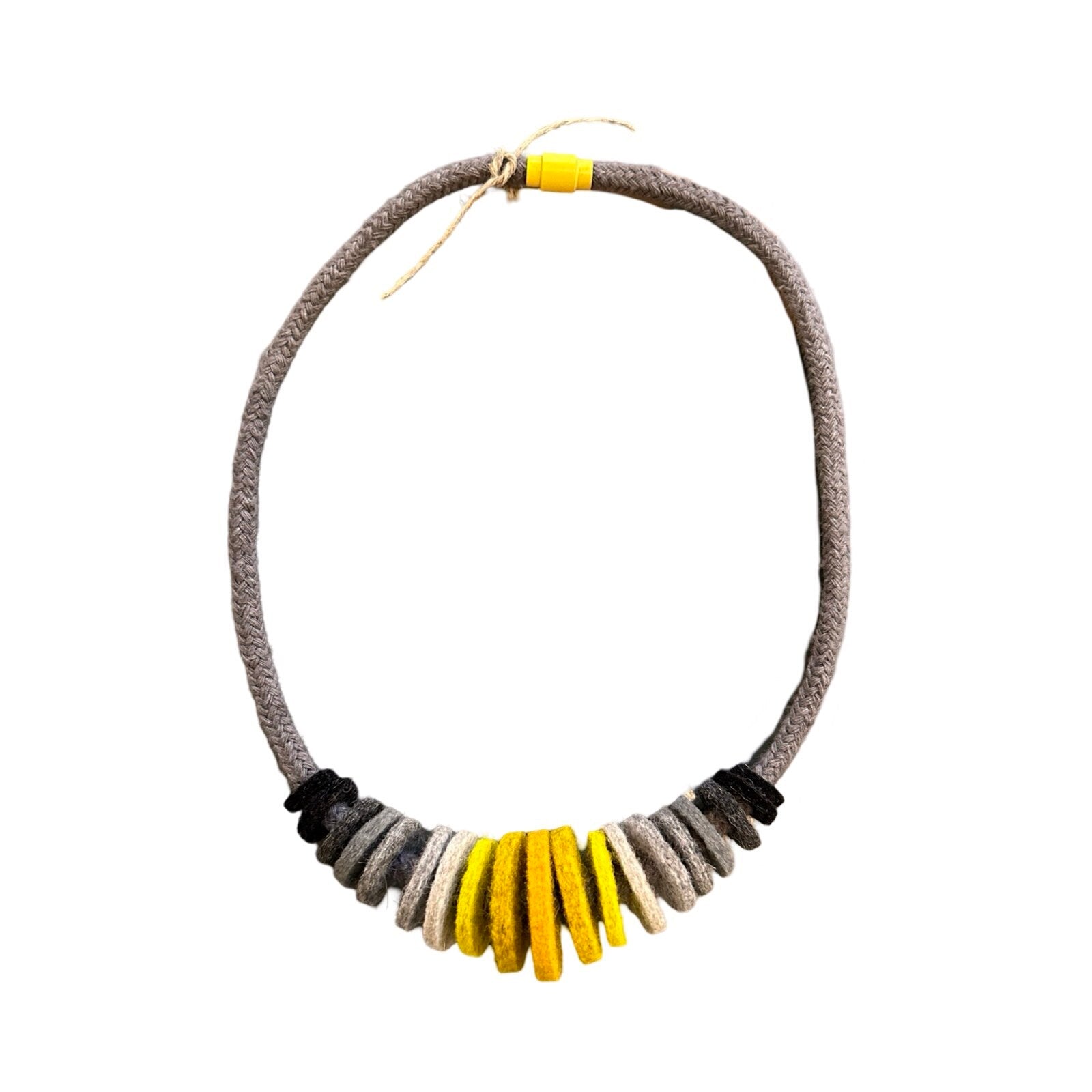 Handmade mustard and grey felt necklace featuring black, dark grey, light grey, yellow and mustard felt circles threaded onto a grey cord, with the largest circles in the centre.