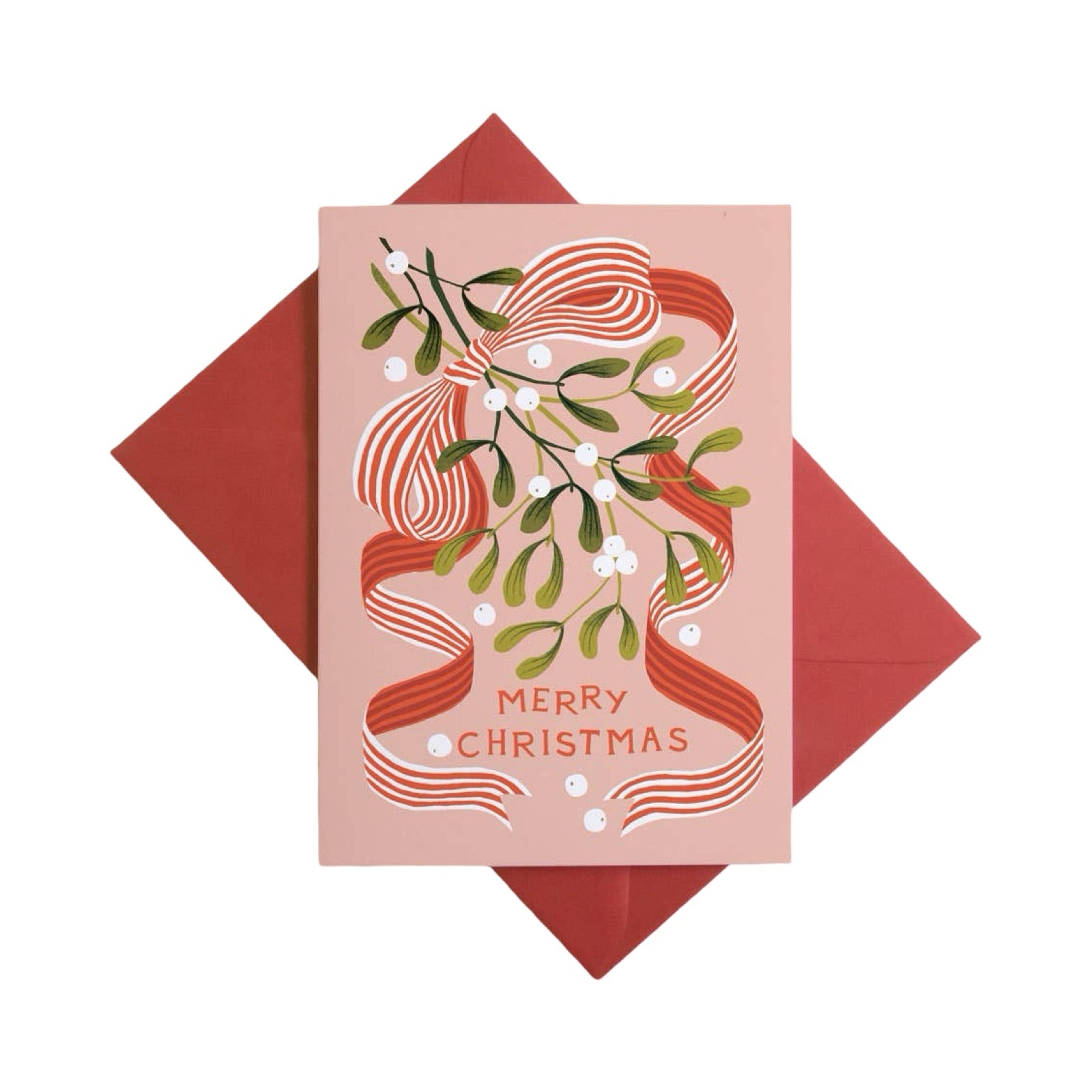 A pink Christmas greeting card with a red striped bow, green mistletoe, and white berries, shown with a red envelope behind it on a white background.