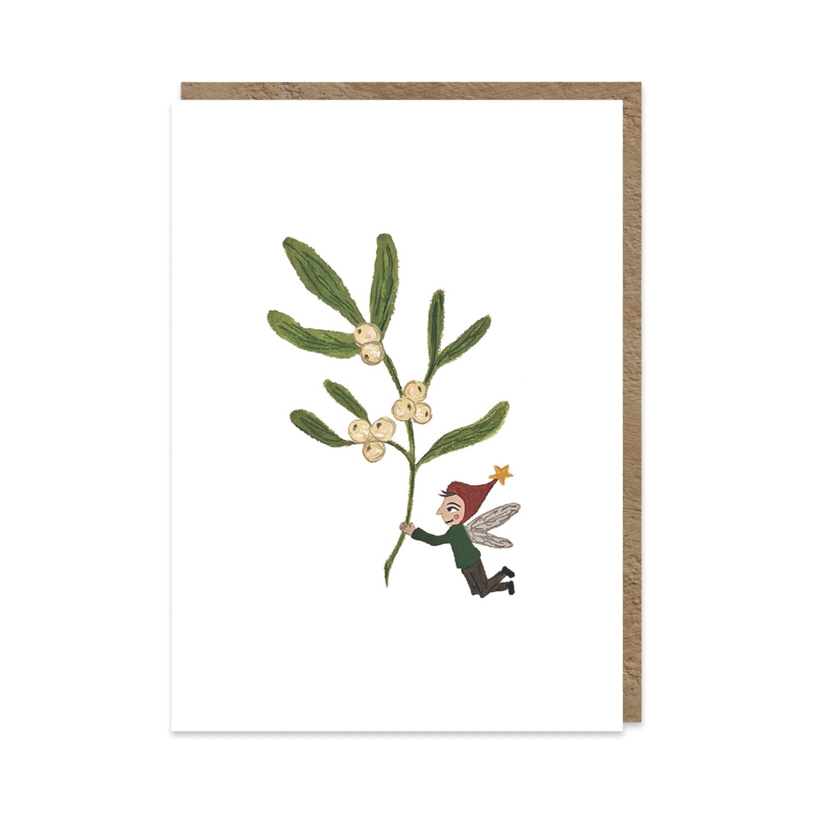 A white greeting card with a brown envelope behind it, featuring an illustration of mistletoe with small white berries and a tiny fairy in a red hat holding the branch.