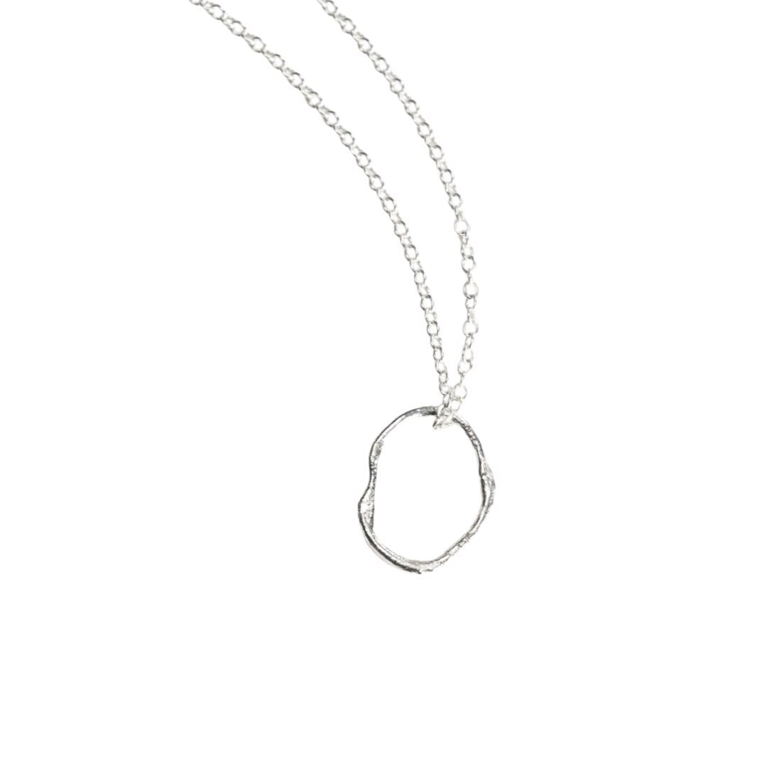Sterling silver organic oval pendant necklace with a molten finish. 