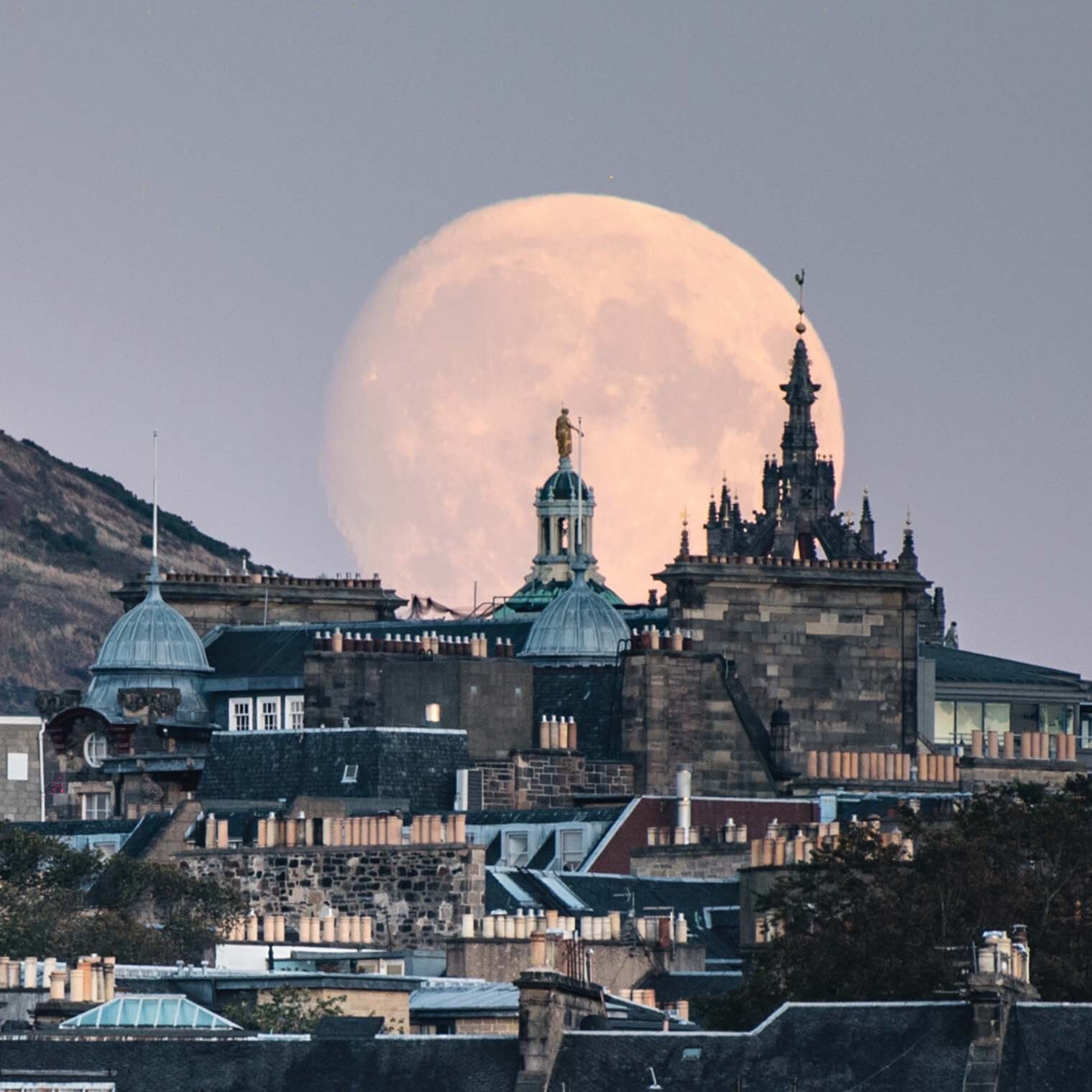 An A6 greeting card of the moon rising, behind the Edinburgh skyline.